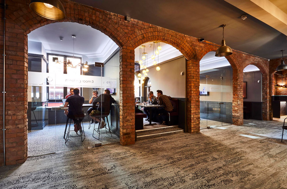 Modern meeting room with exposed brick arches for versatile events and networking.