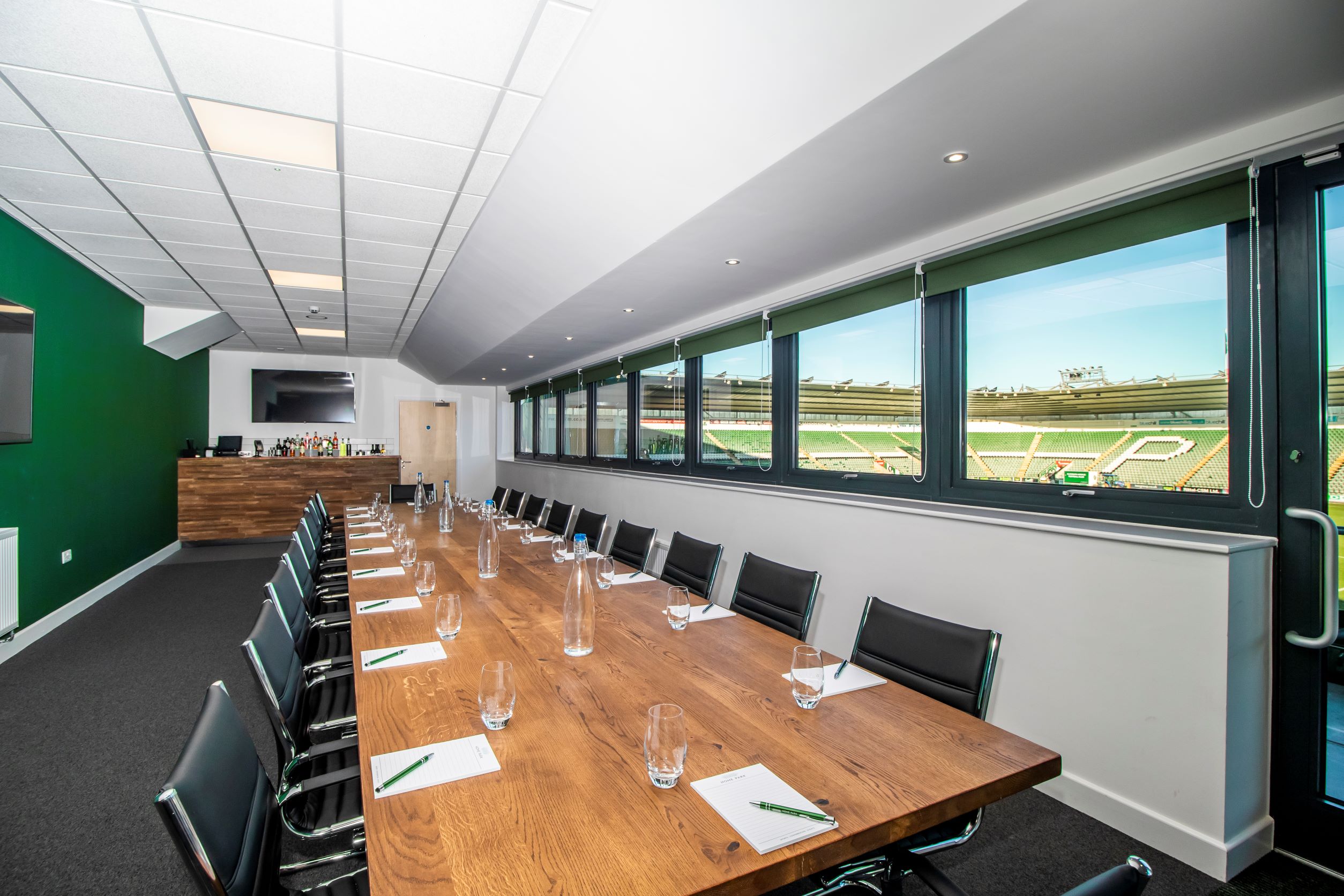 Modern meeting room with wooden table at Home Park Stadium for corporate events.