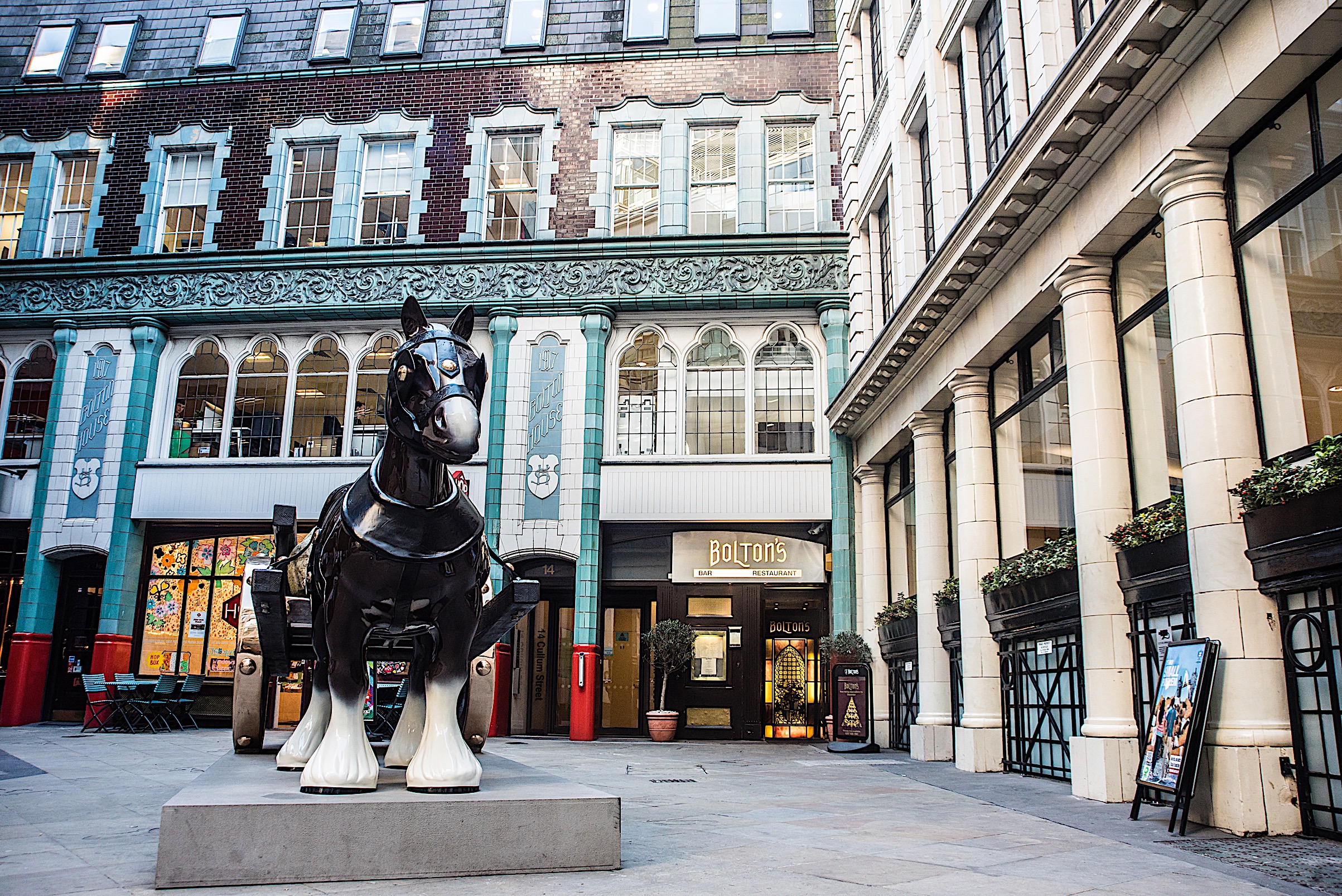 Charming Bolton restaurant courtyard with striking horse sculpture for events and gatherings.