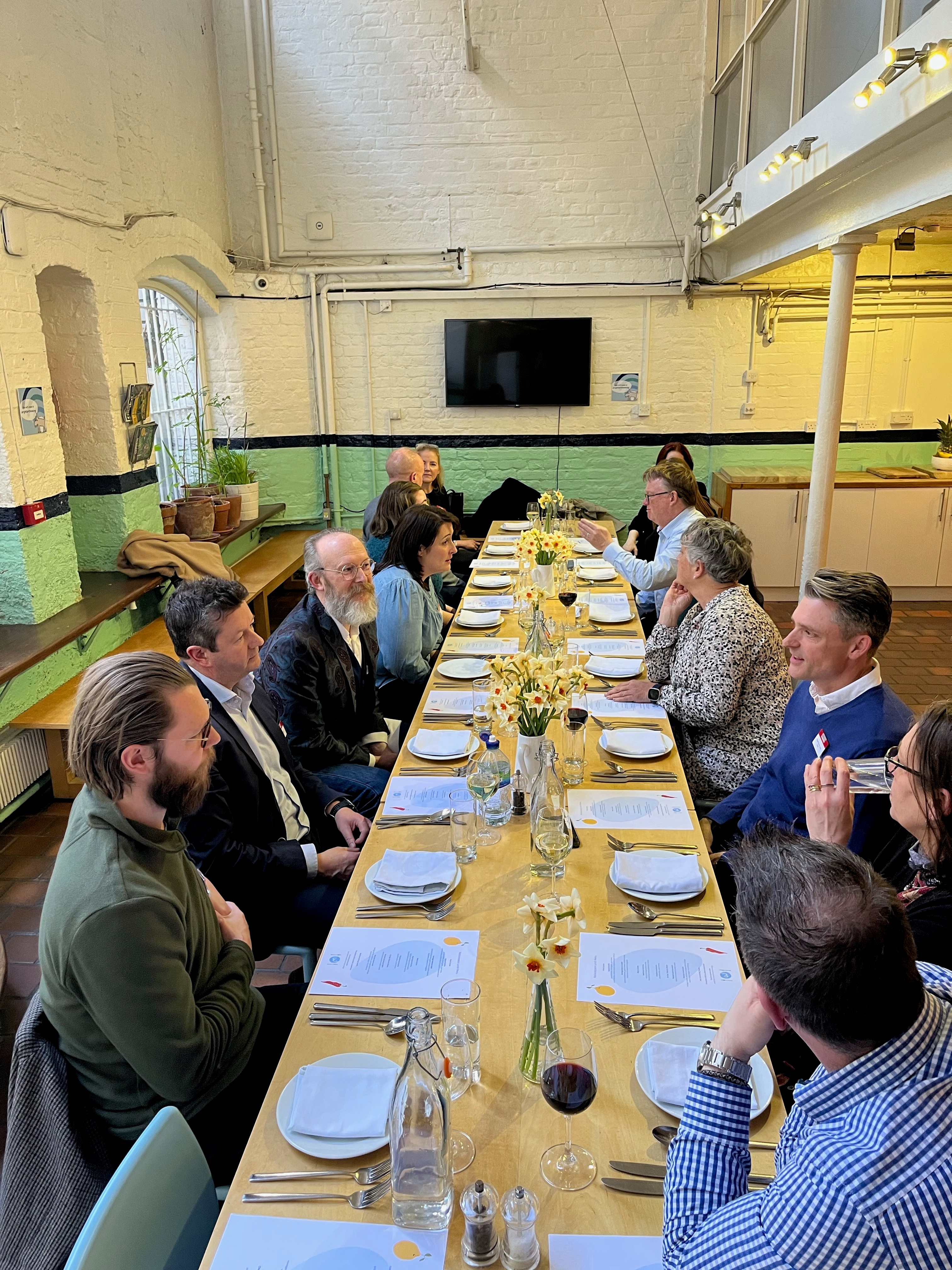 Elegant dining table at Wallacespace St Pancras for networking event with floral centerpieces.