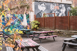 Vibrant Beer Garden in Liverpool with colorful picnic tables for outdoor events.