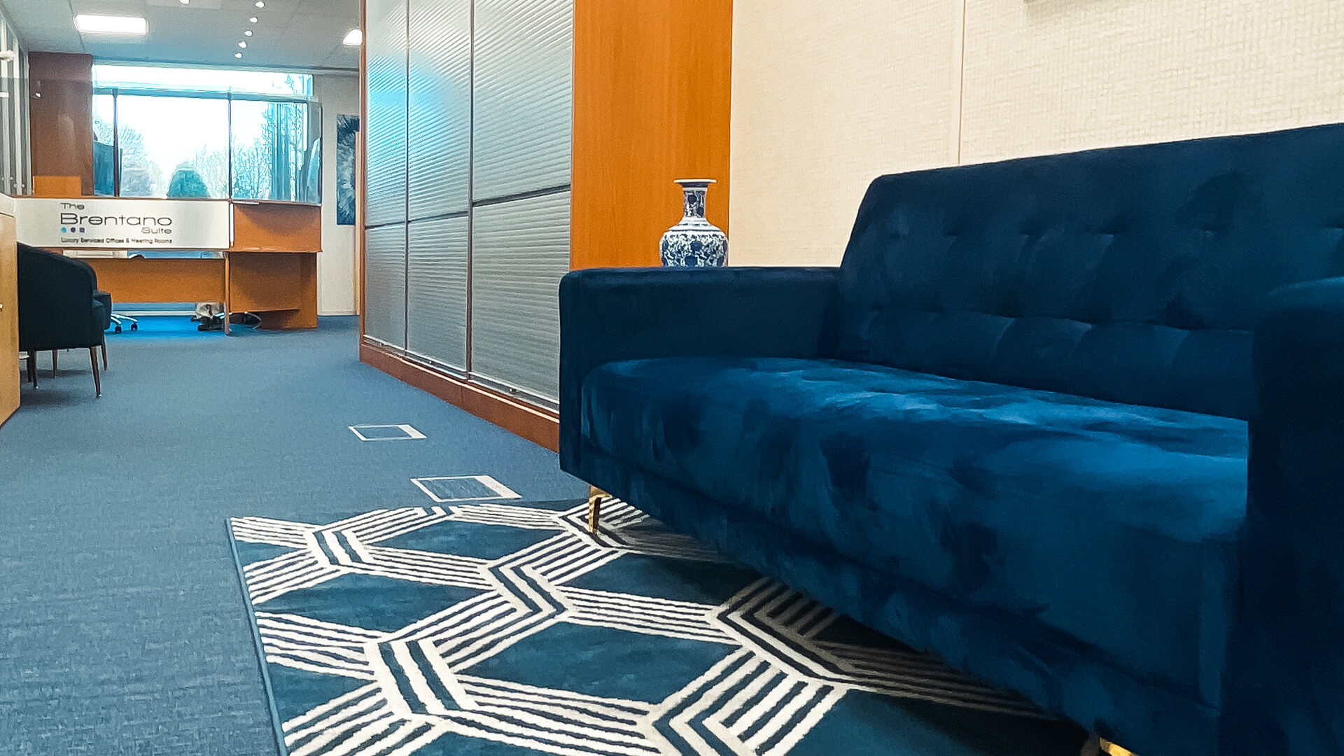 Stylish waiting area with plush blue sofa for meetings and events at Catalyst House.