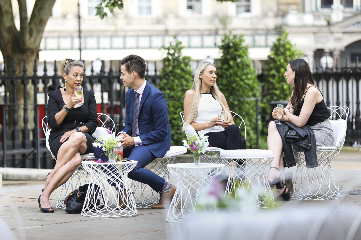 Outdoor networking event at St Martin-in-the-Fields with modern seating and floral decor.