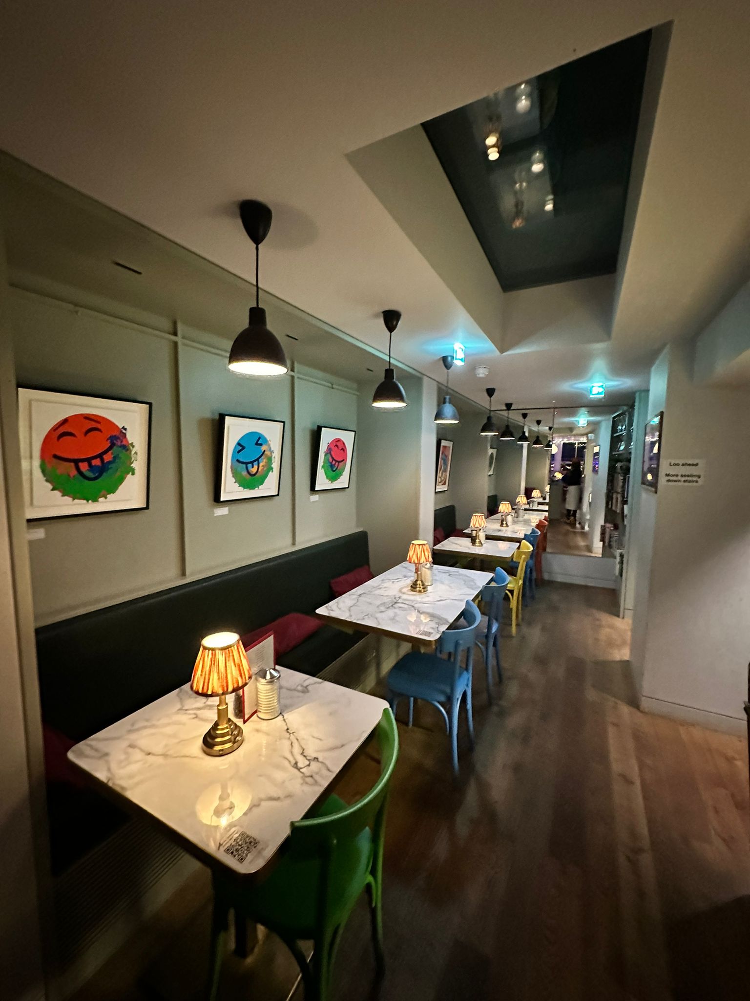 Stylish event space at Sam's Cafe with elegant lamps and colorful chairs for gatherings.