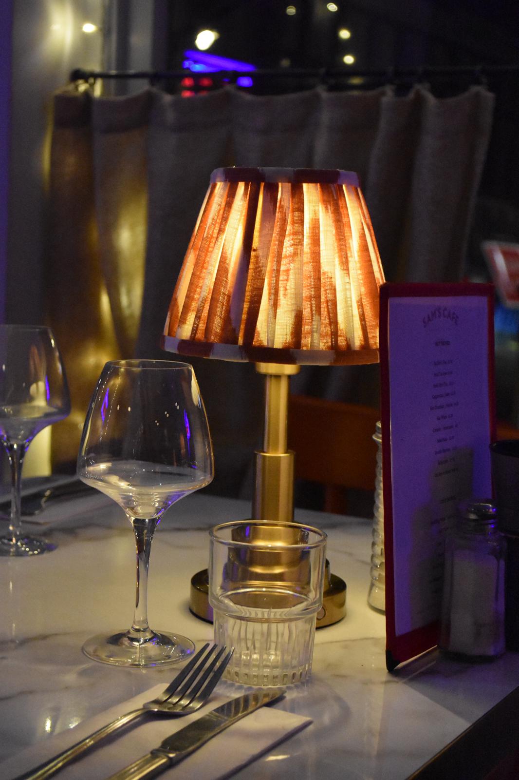 Elegant dining table at Sam's Cafe with stylish lamp, perfect for upscale events.