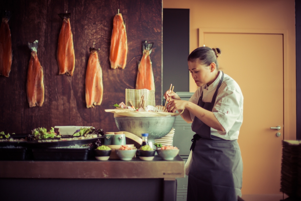 Chef preparing gourmet dishes in stylish kitchen for private dining events.