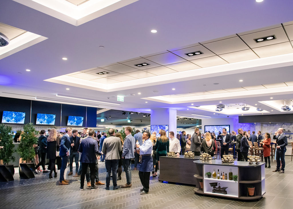 Networking event at Tottenham Hotspur Stadium with modern decor and vibrant atmosphere.