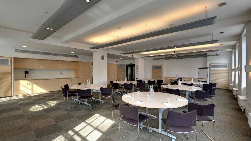 Versatile meeting space in Friends House with round tables for workshops and presentations.