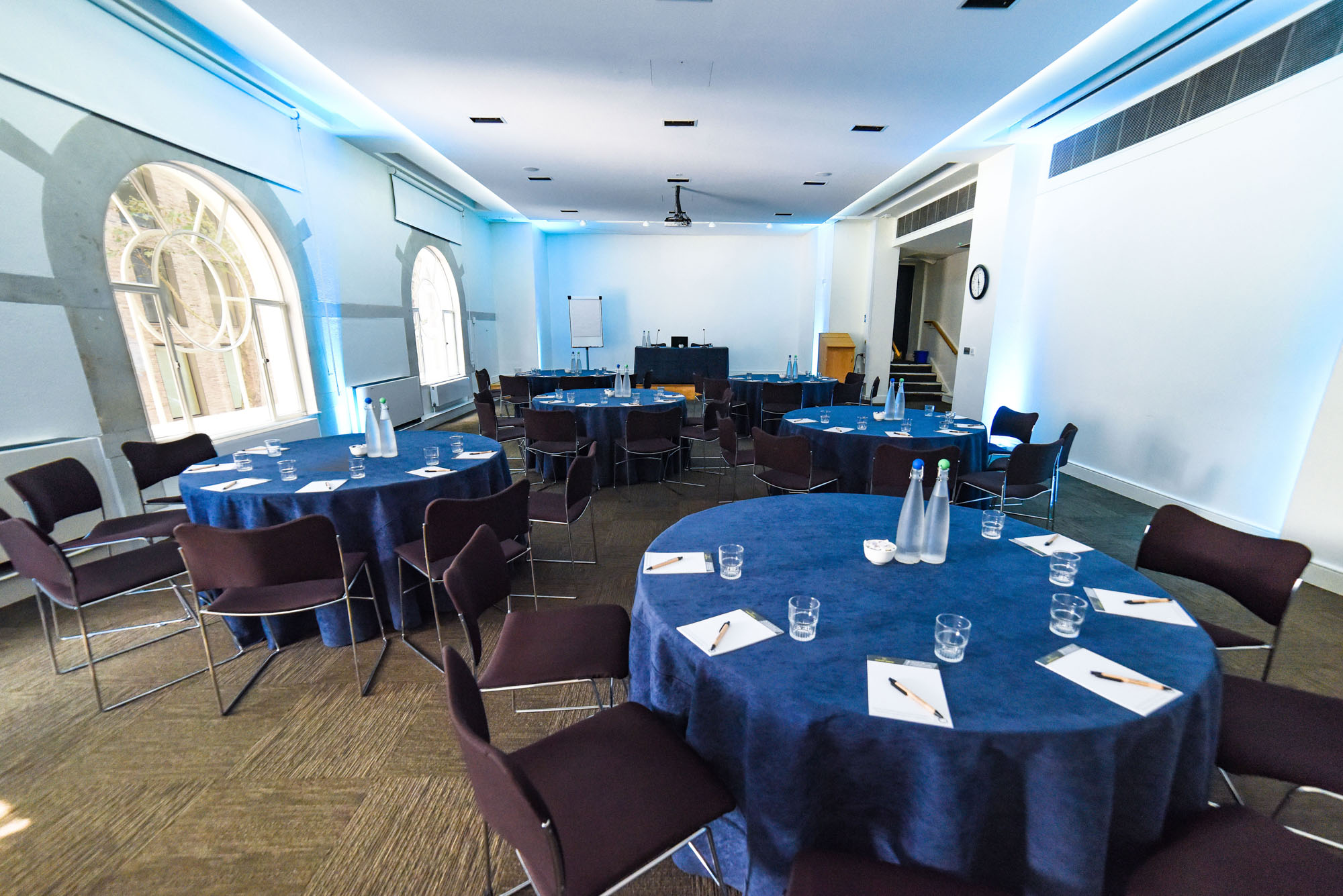 Meeting space with round tables, blue tablecloths for workshops and conferences.