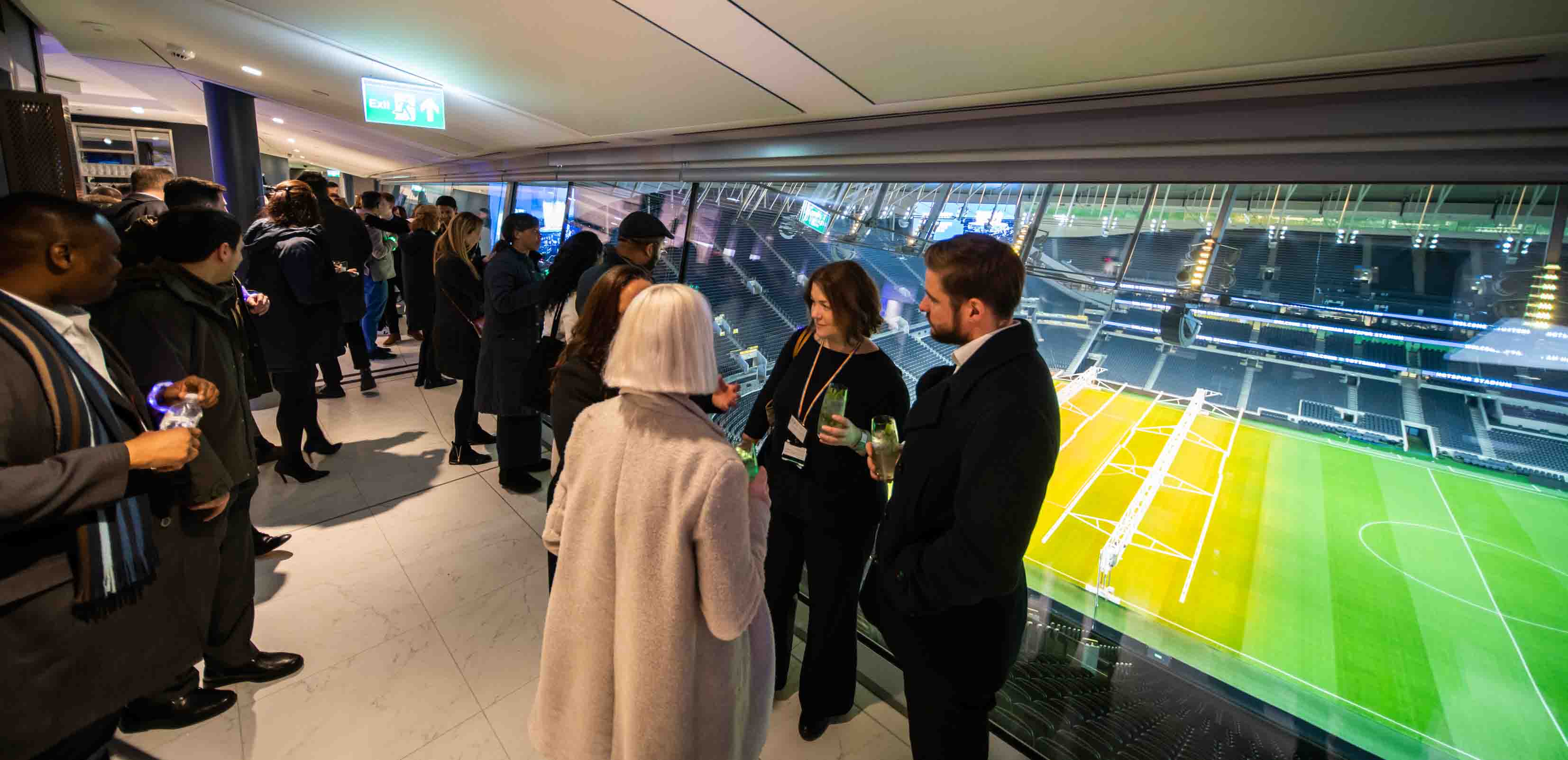Networking event at Tottenham Hotspur Stadium with a view of the sports field.