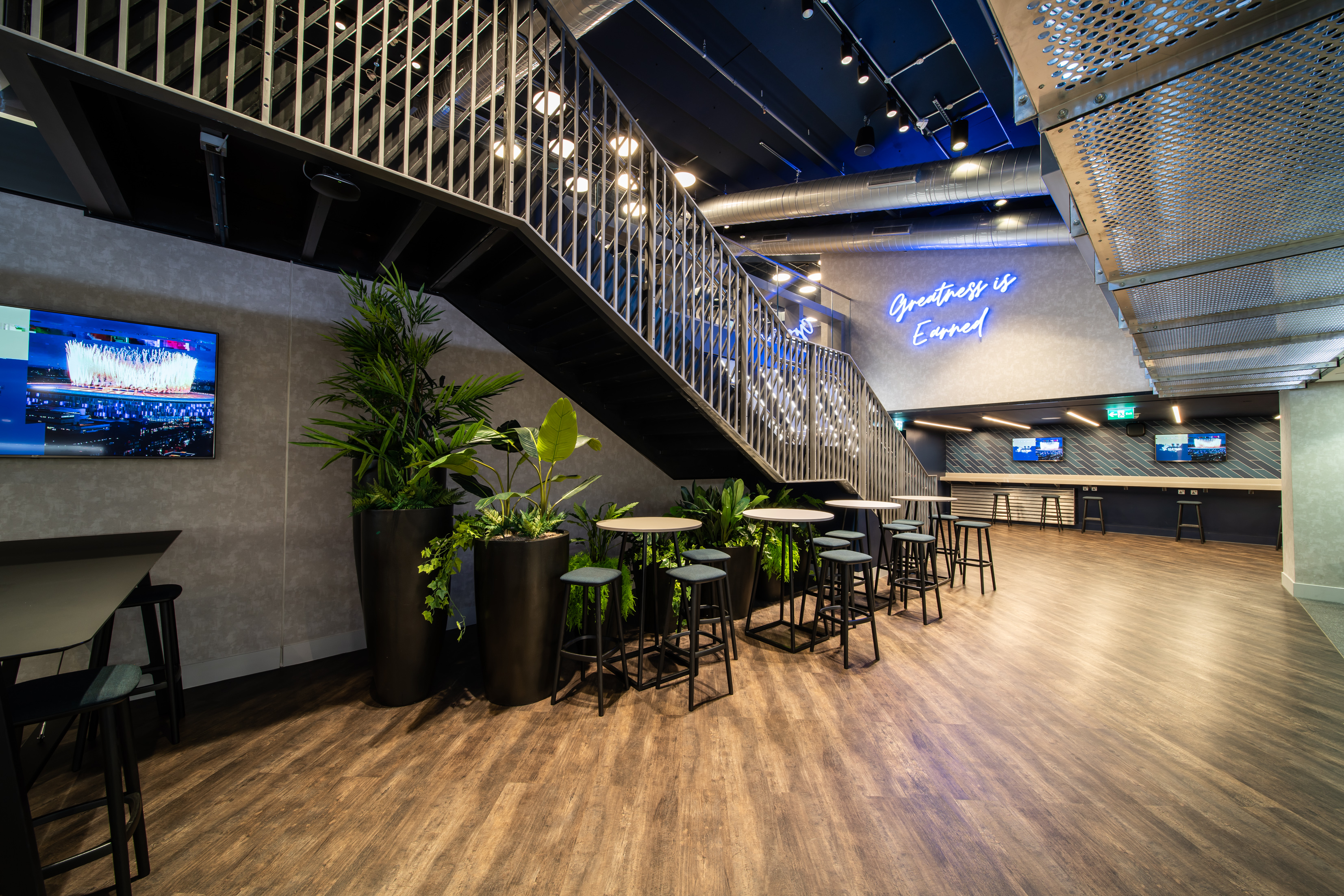 Modern event space in Tottenham Hotspur Stadium with high-top tables, perfect for networking.