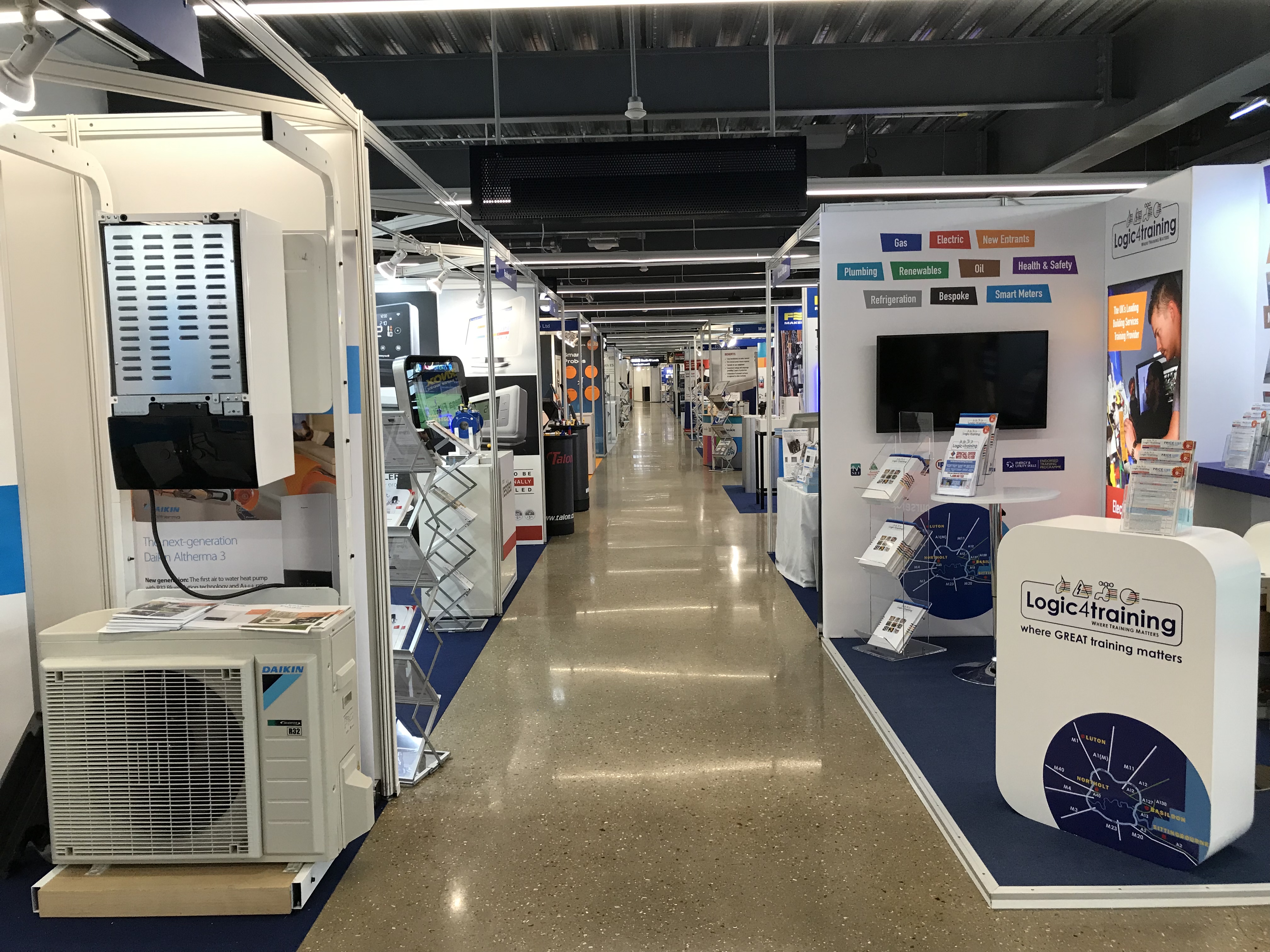 Exhibition hall at Tottenham Hotspur Stadium with vendor booths for networking event.