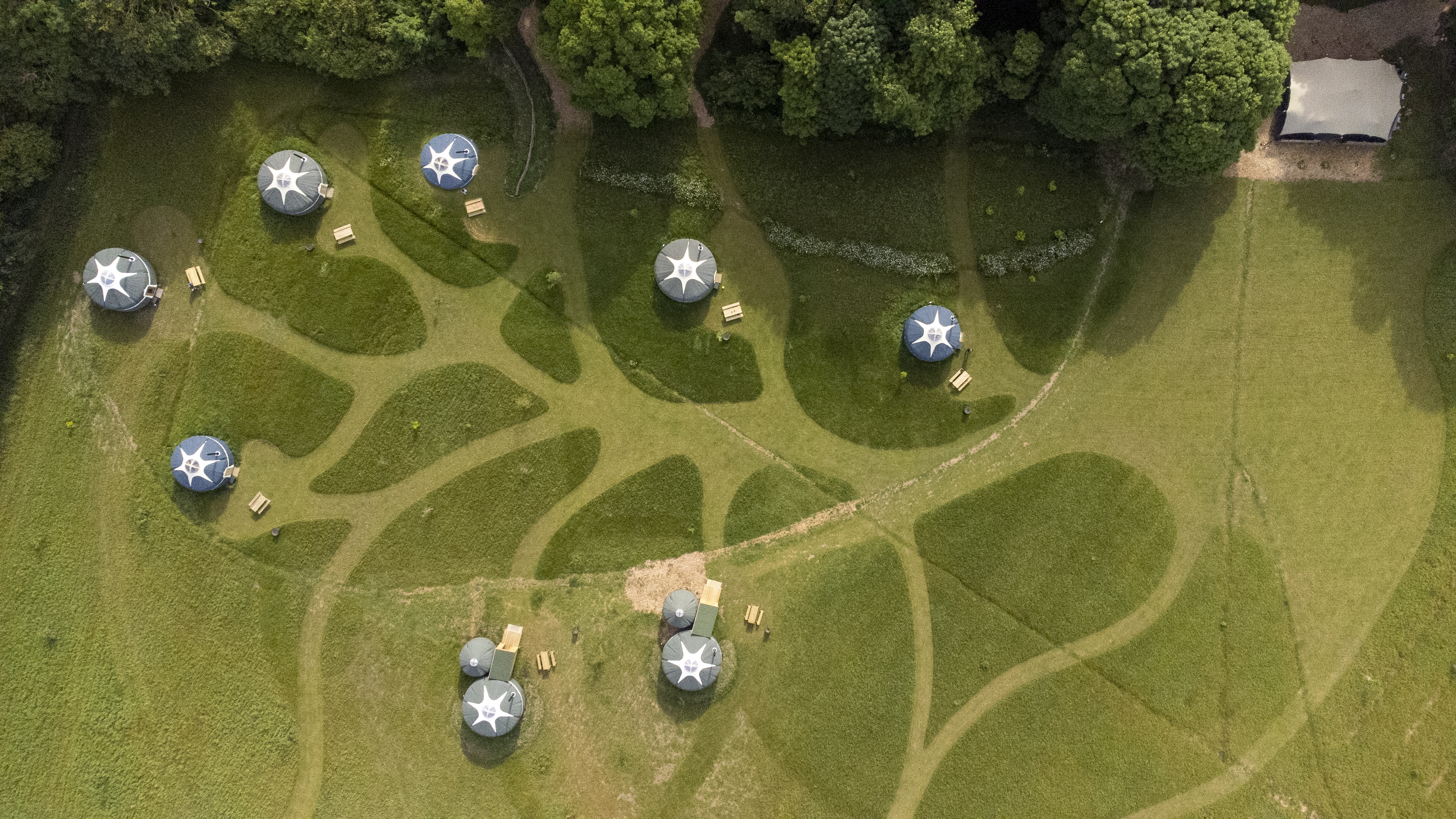 Geodesic domes in lush greenery at Wild Meadow, perfect for outdoor events and workshops.