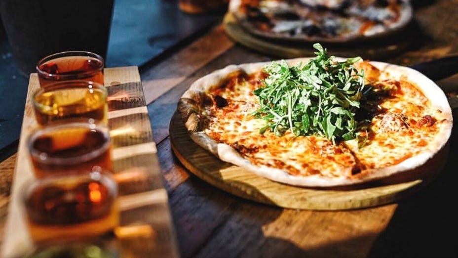 "Delicious pizza with arugula at Cider Snug, perfect for events and networking."