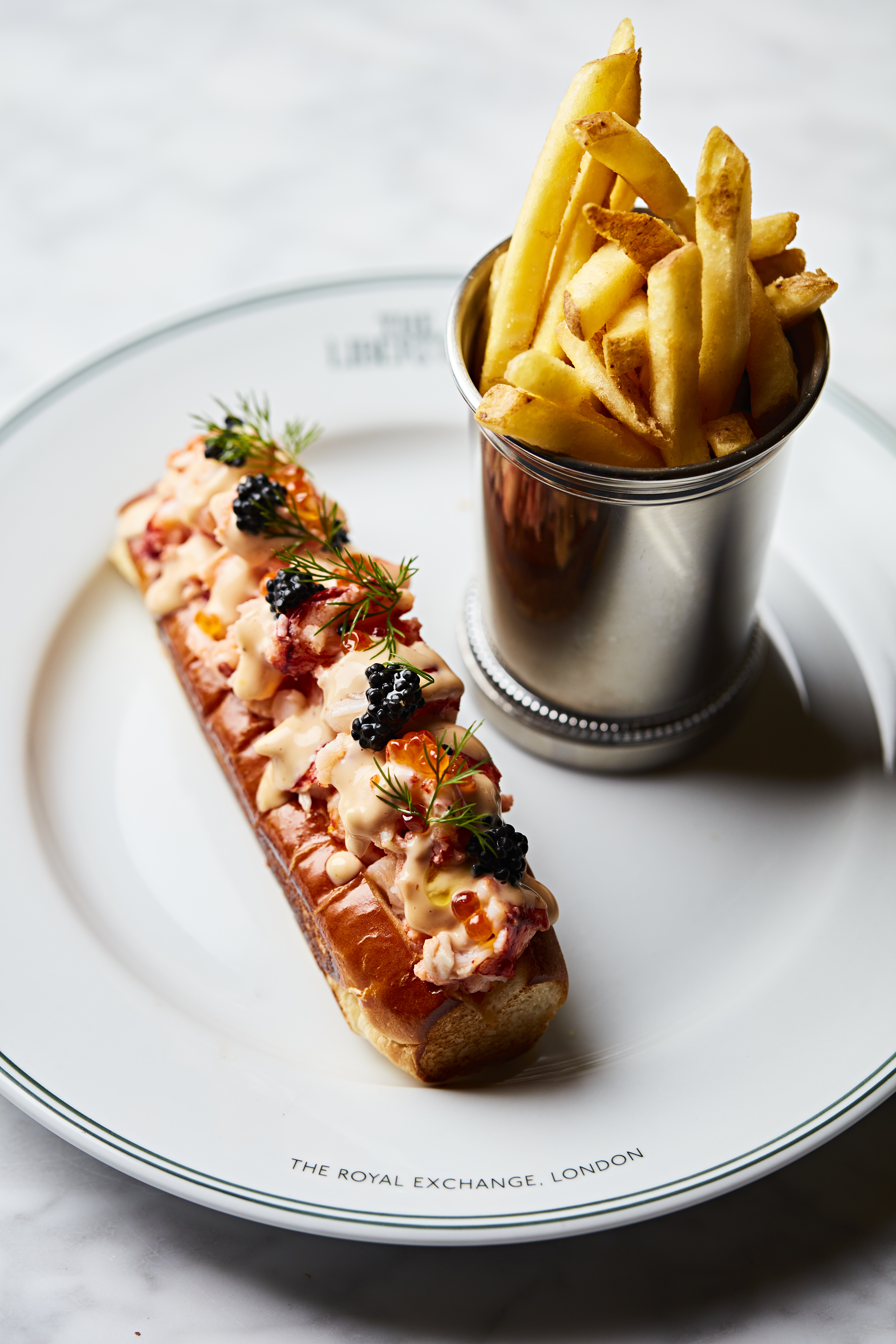 Gourmet lobster roll with fries at The Whiskey Vault, perfect for upscale events.