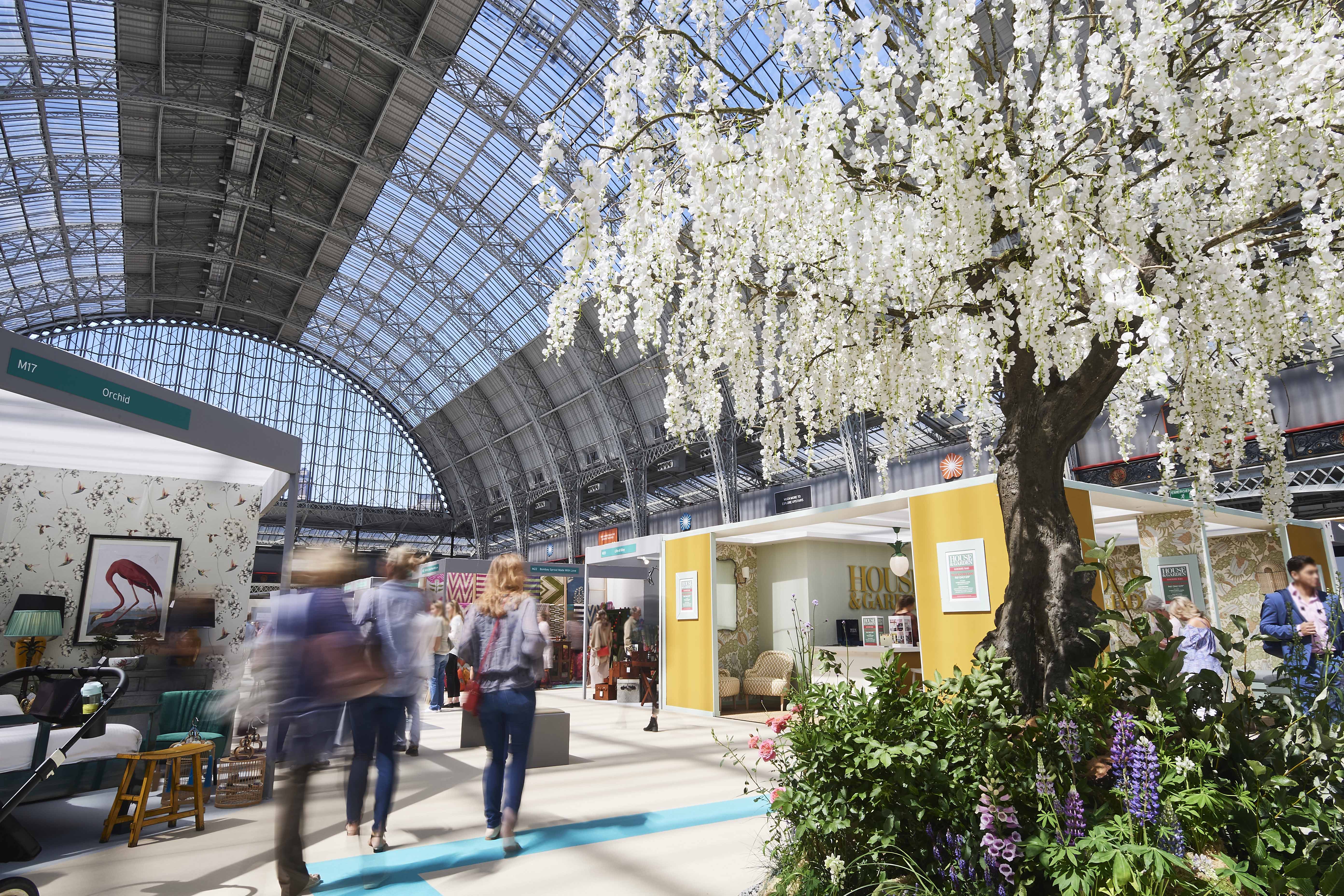 Vibrant exhibition in The Grand Hall, Olympia with elegant floral displays for networking events.
