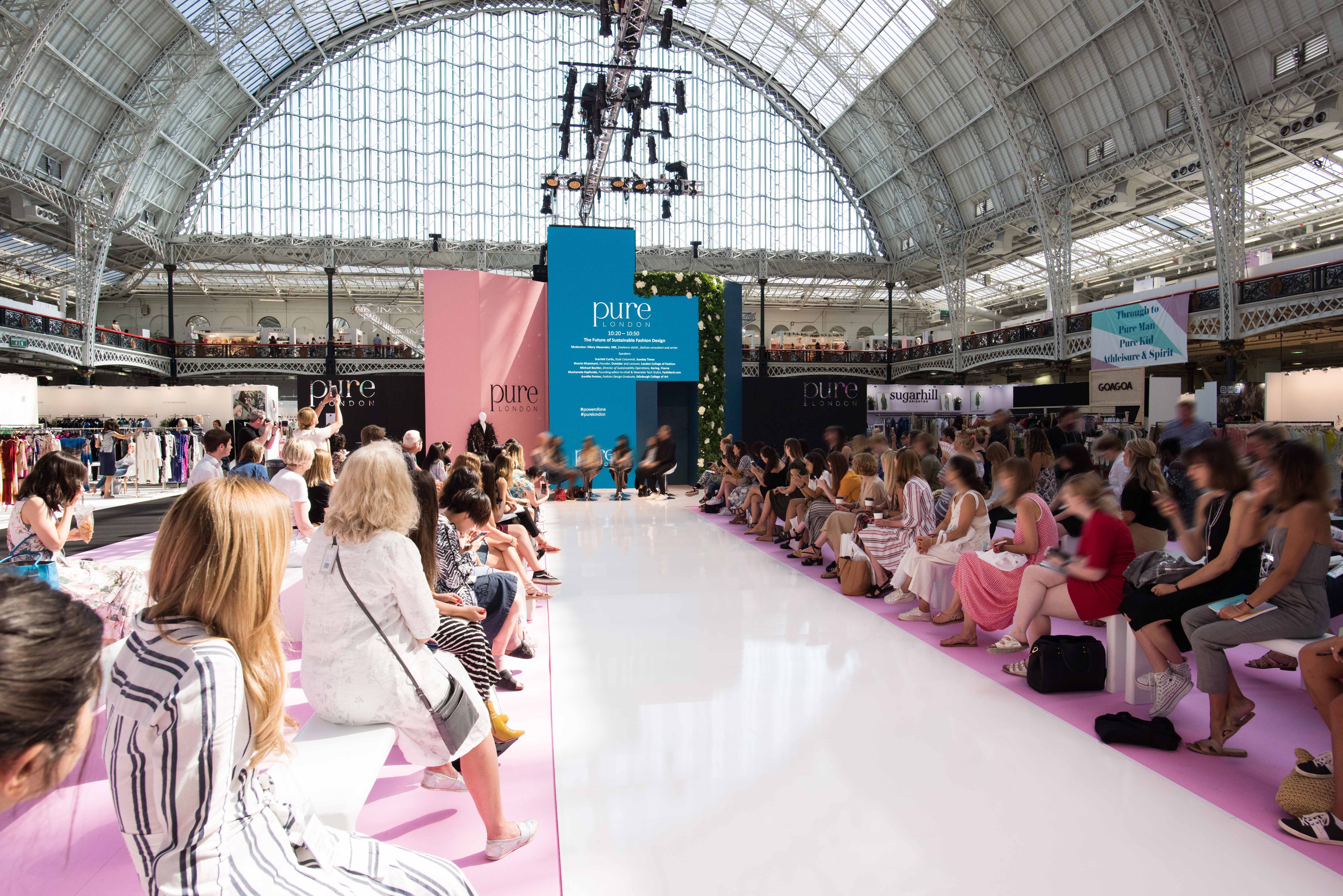 Vibrant fashion event in The Grand Hall, Olympia with a stunning runway and engaged audience.