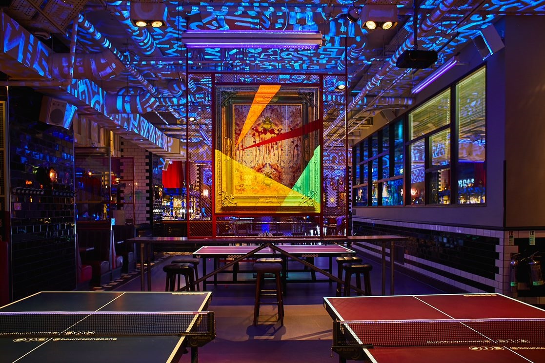 Vibrant event space with ping pong tables for corporate retreats and team-building activities.