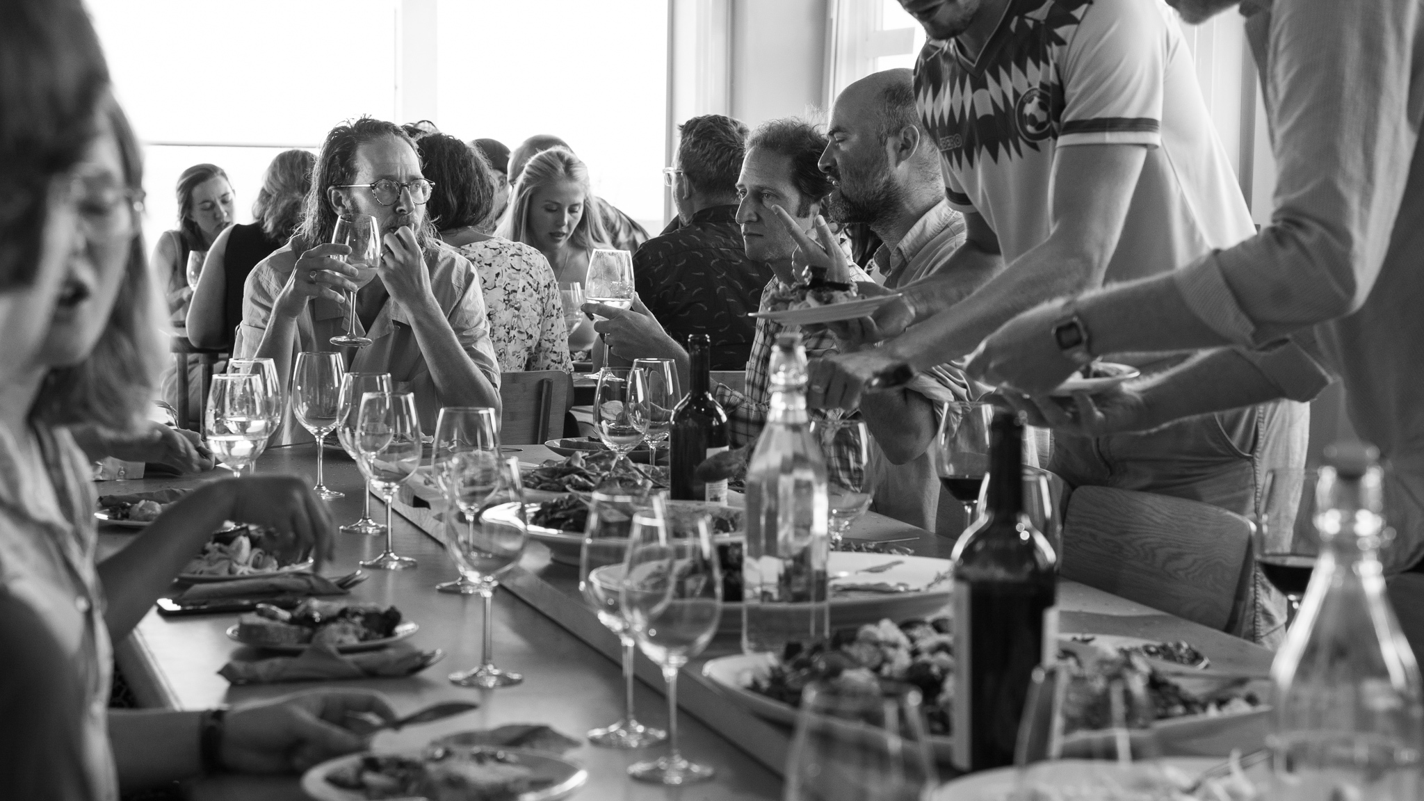 Lively dining event at Faith In Strangers with elegant glassware and networking opportunities.