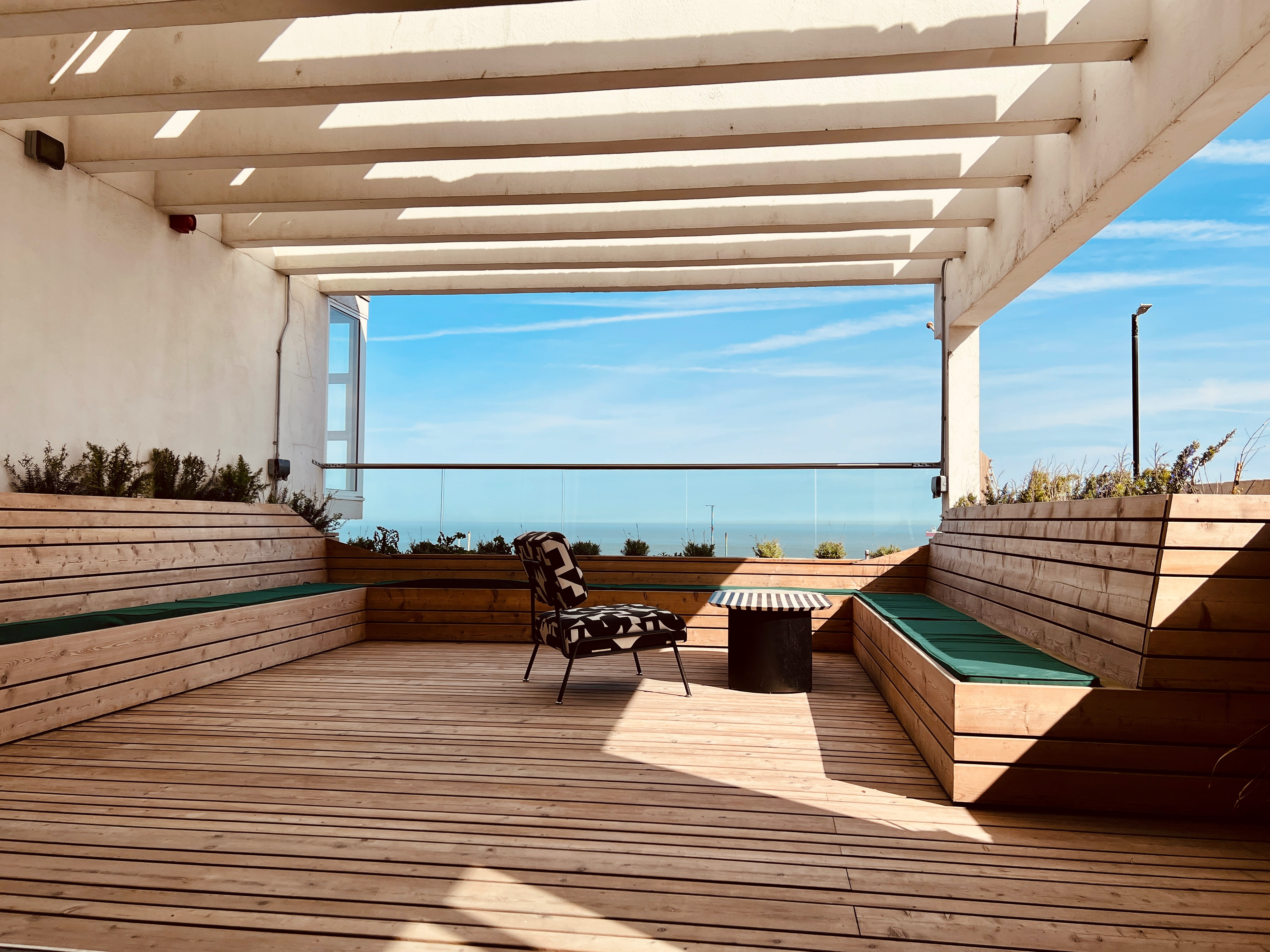 Stylish outdoor meeting space with ocean view for creative gatherings and brainstorming.