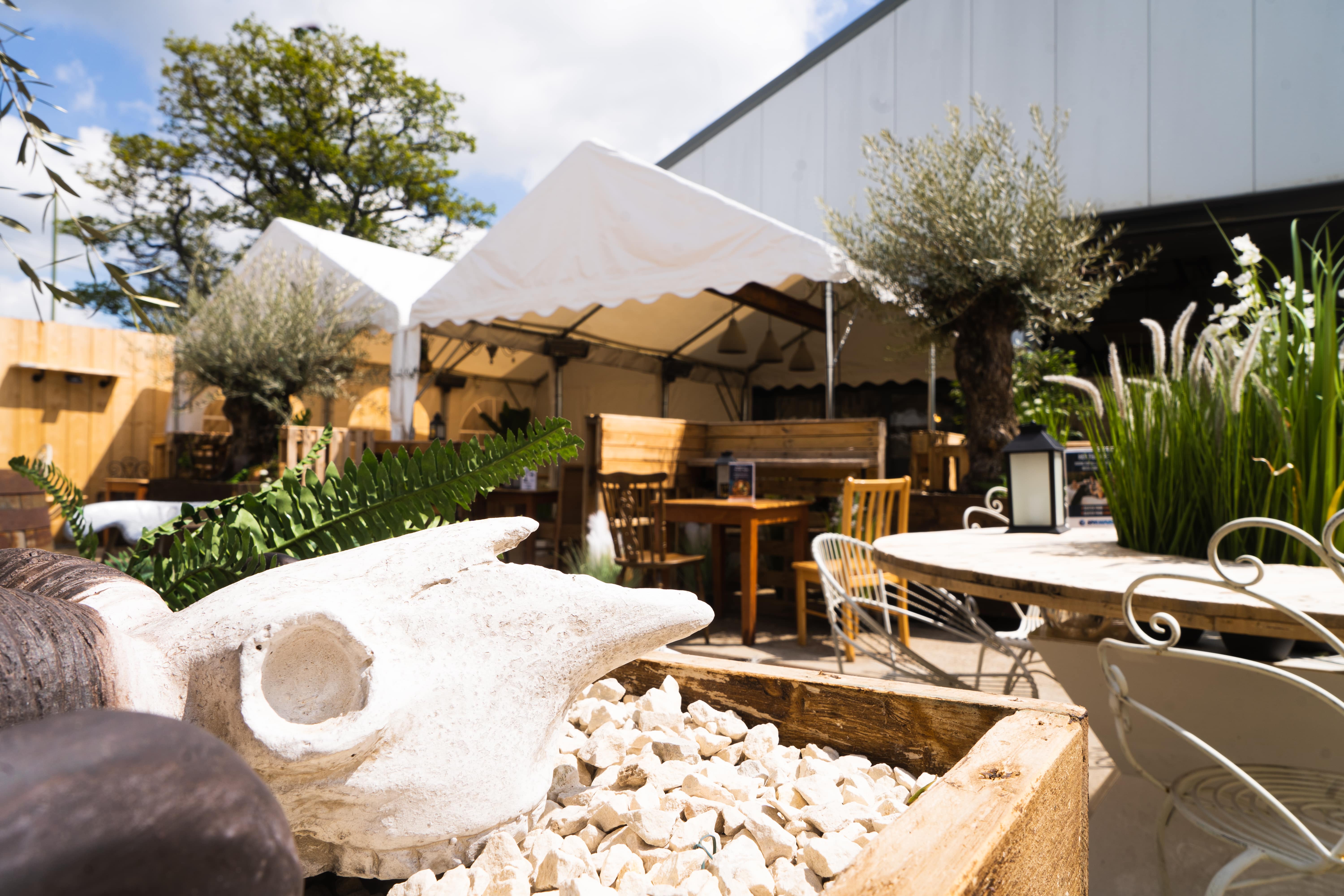 Elegant outdoor event space with tents and greenery, ideal for gatherings and networking.