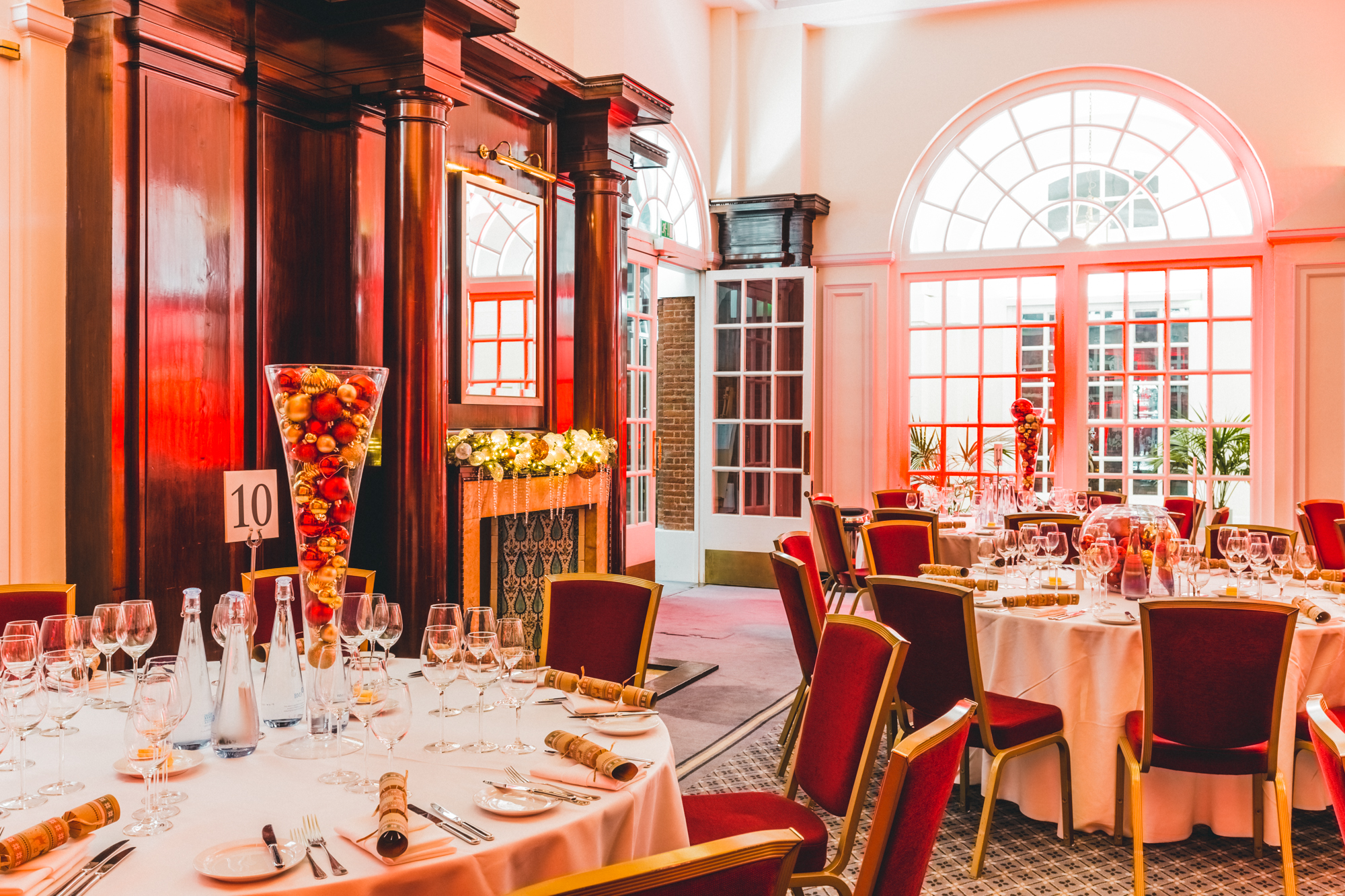 Elegant dining room at BMA House for Christmas parties, featuring white linens and floral decor.