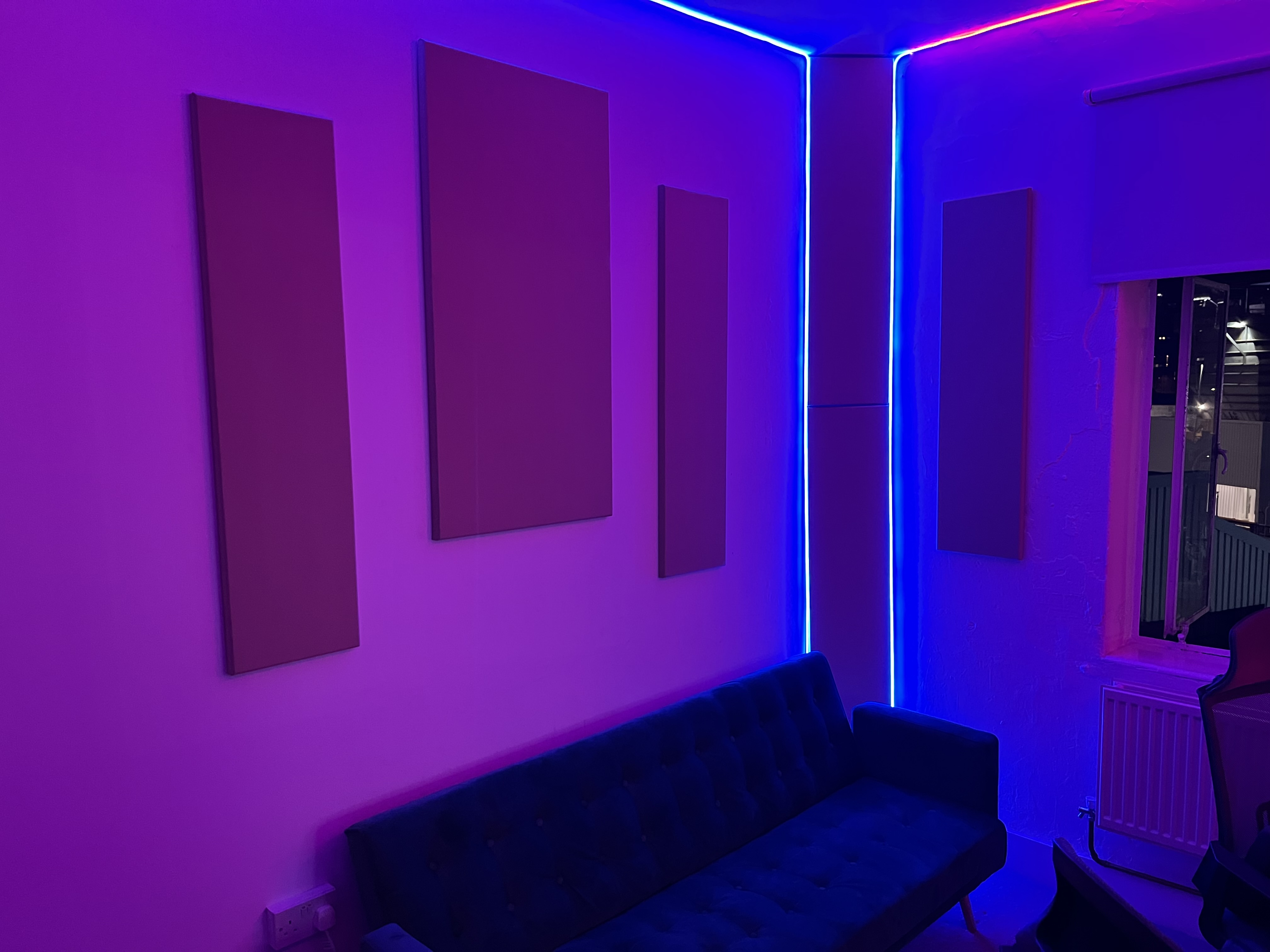 Modern music recording studio with blue couch, perfect for networking events and meetings.