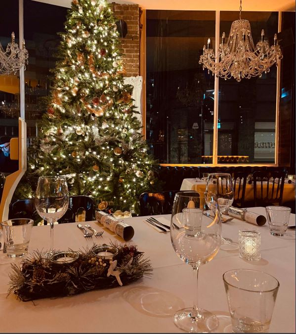 Elegant dining table with glassware and Christmas tree for holiday events in Q-Shoreditch.