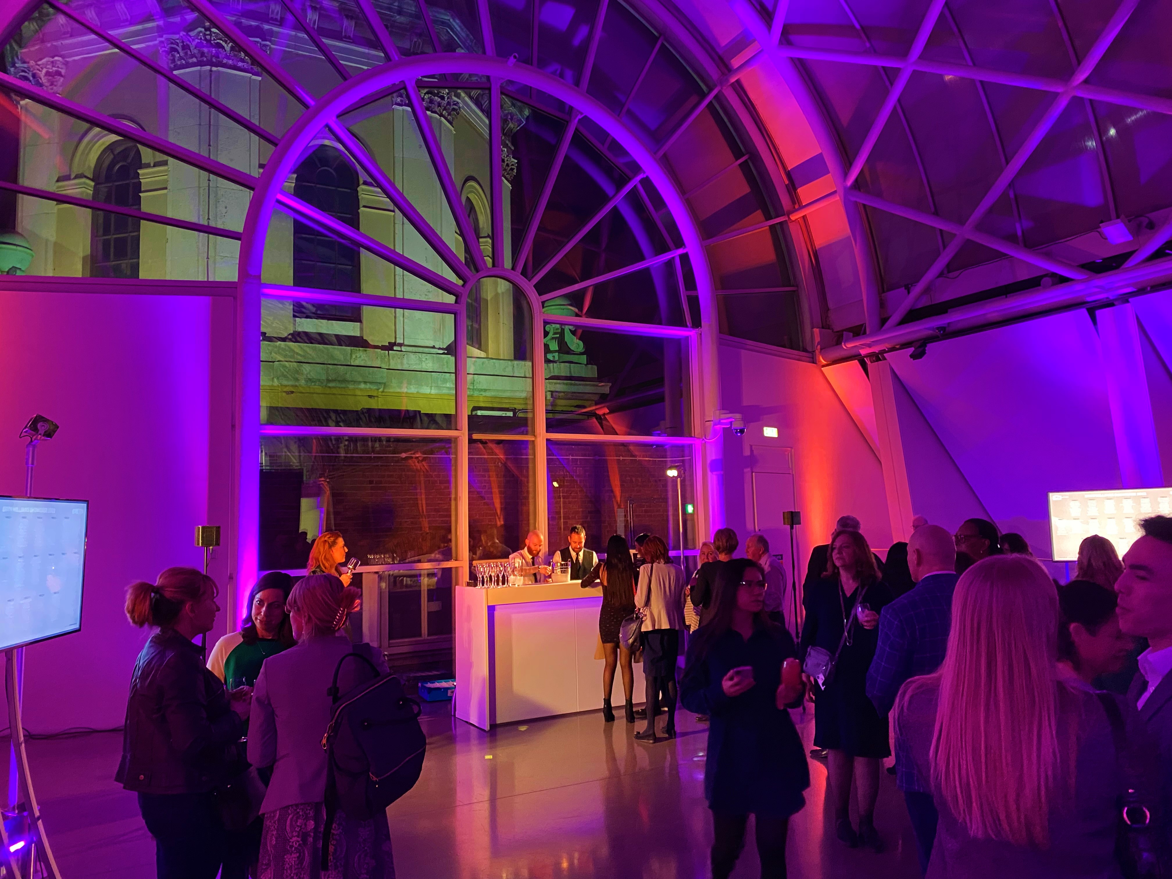 Atrium at IWM London, vibrant event space with dynamic lighting for networking events.