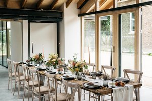 Orchard Room at The Glass House: elegant meeting space with long wooden table, ideal for events.