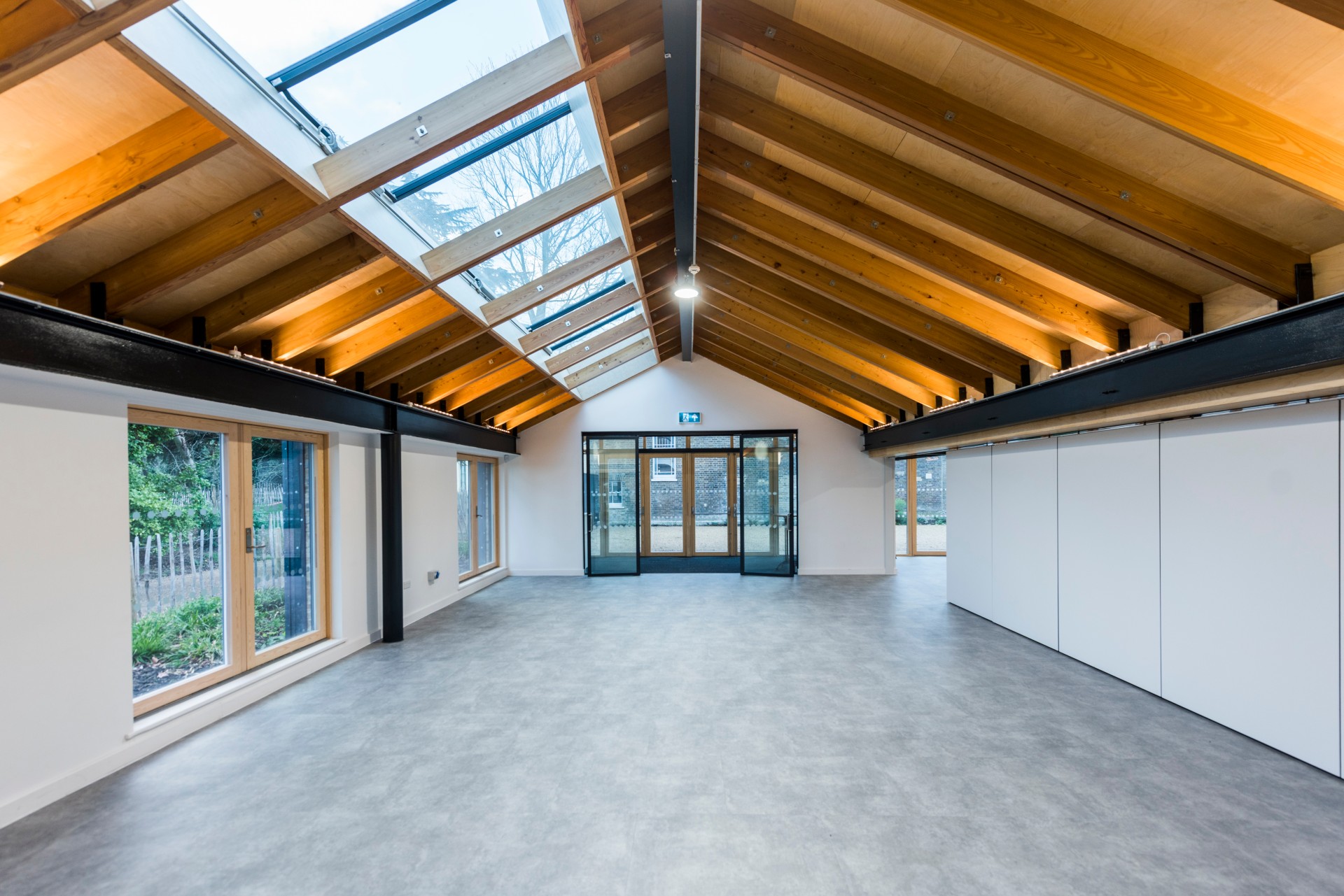 Versatile event space in The Glass House with high ceilings, ideal for meetings and gatherings.