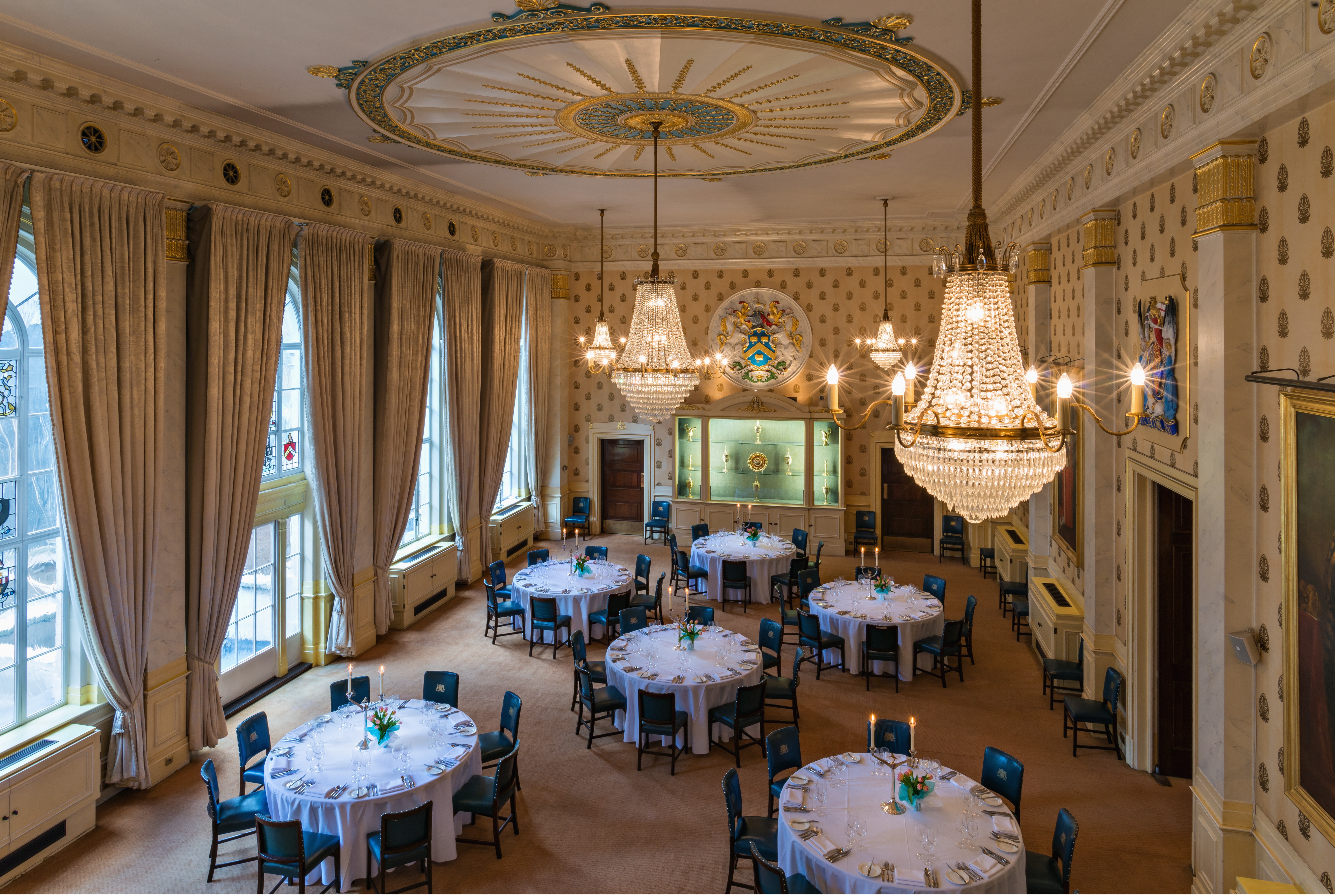Elegant Great Hall with round tables and floral centerpieces for upscale events.