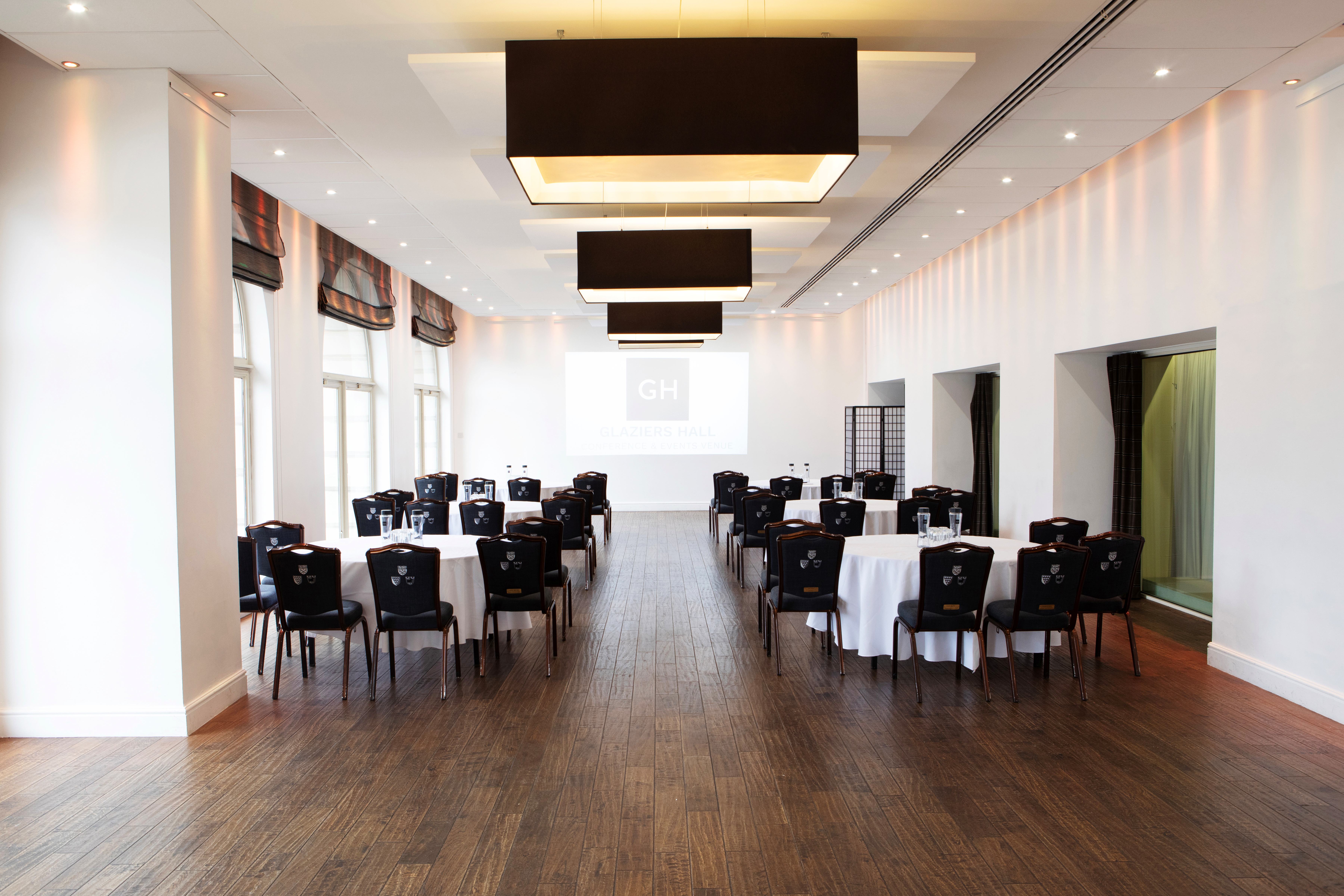 Versatile River Room at Glaziers Hall with round tables for corporate events and gatherings.