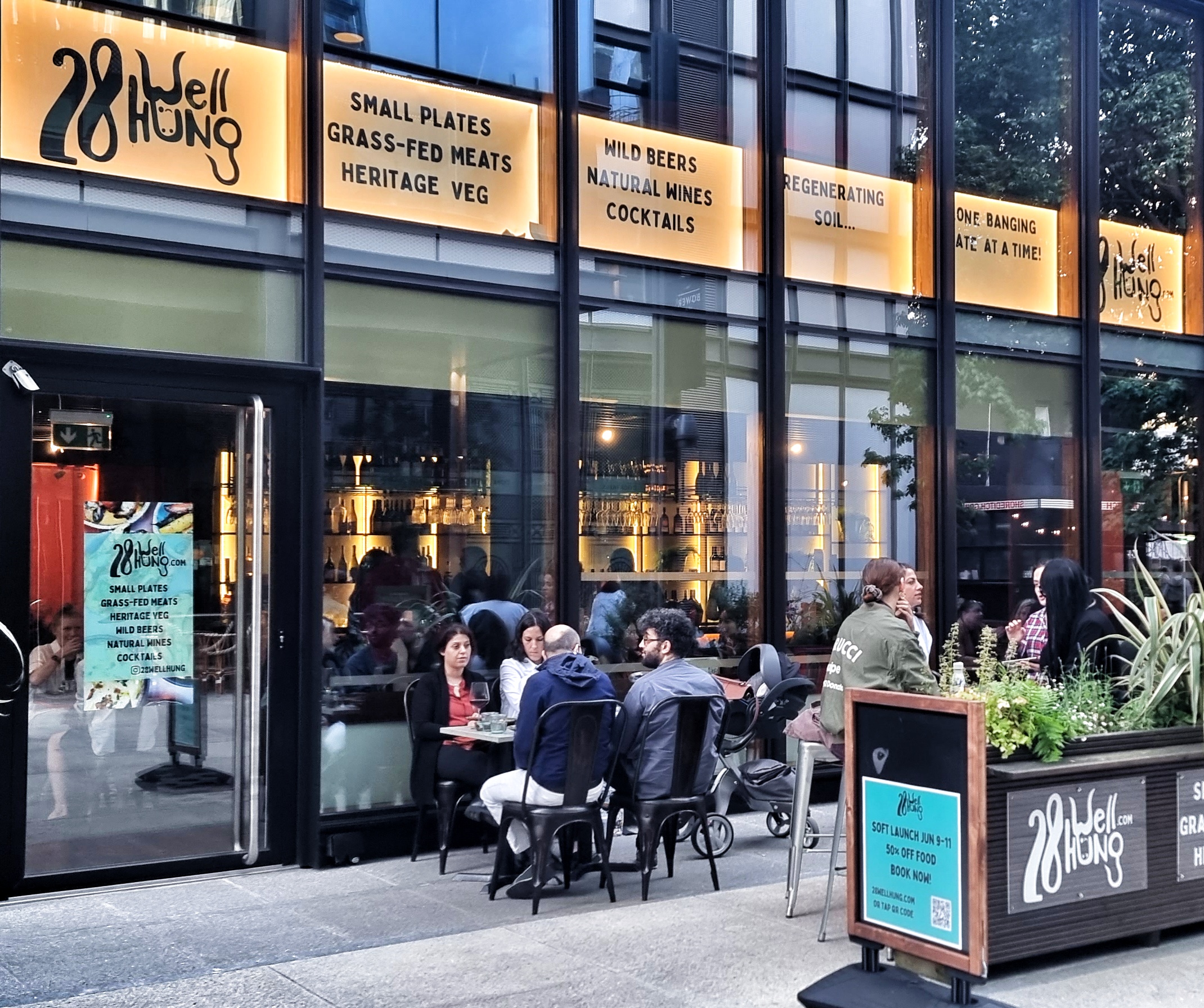 Vibrant outdoor dining venue with glass facade, perfect for networking events and gatherings.