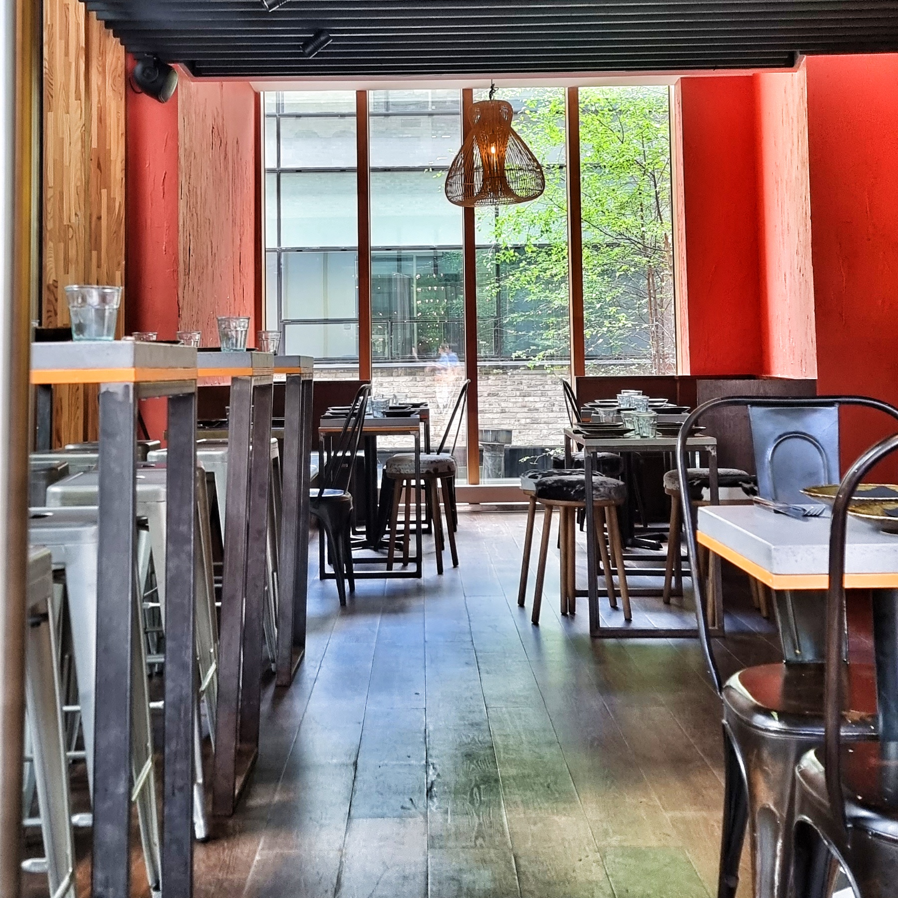 Modern dining venue with wooden floors, ideal for meetings and events.