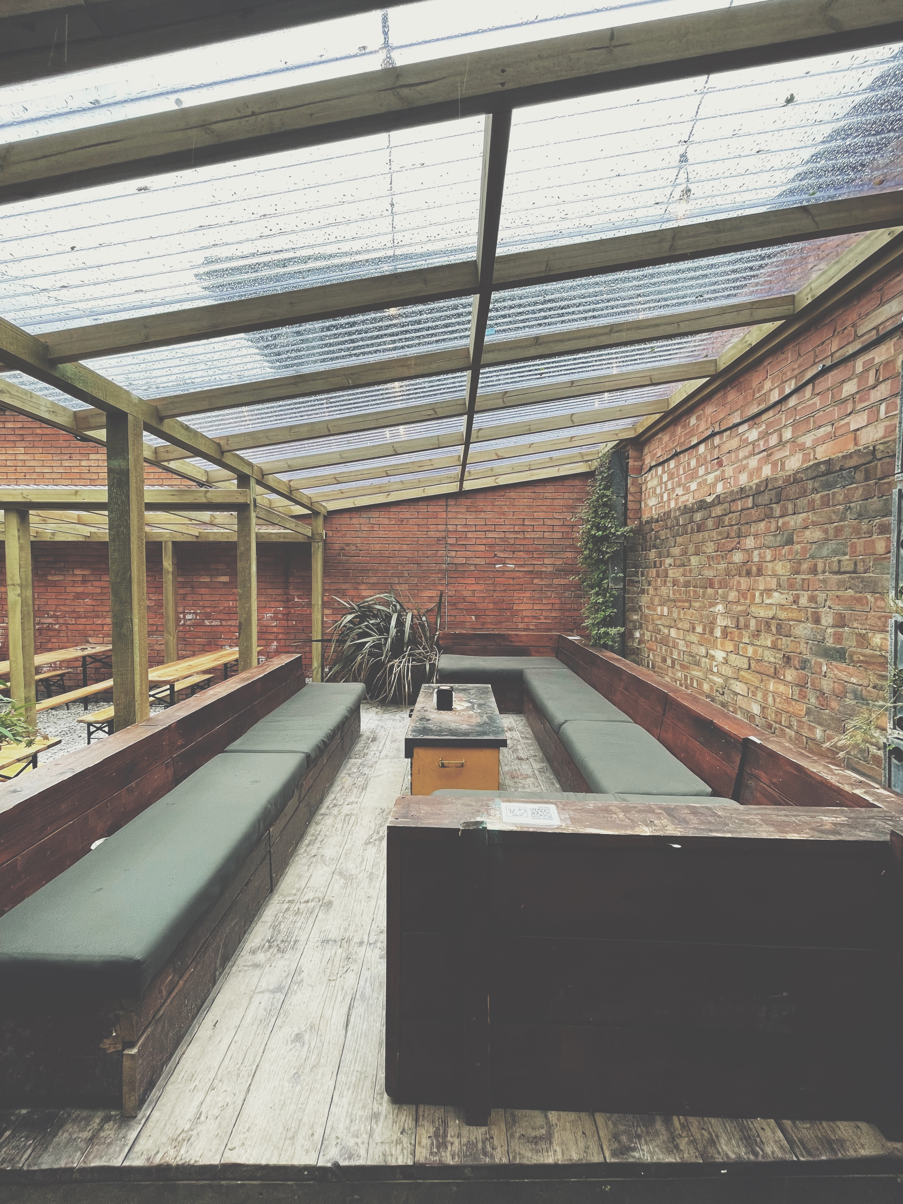 Outdoor meeting space at Deviant & Dandy Brewery with rustic charm and fire pit.