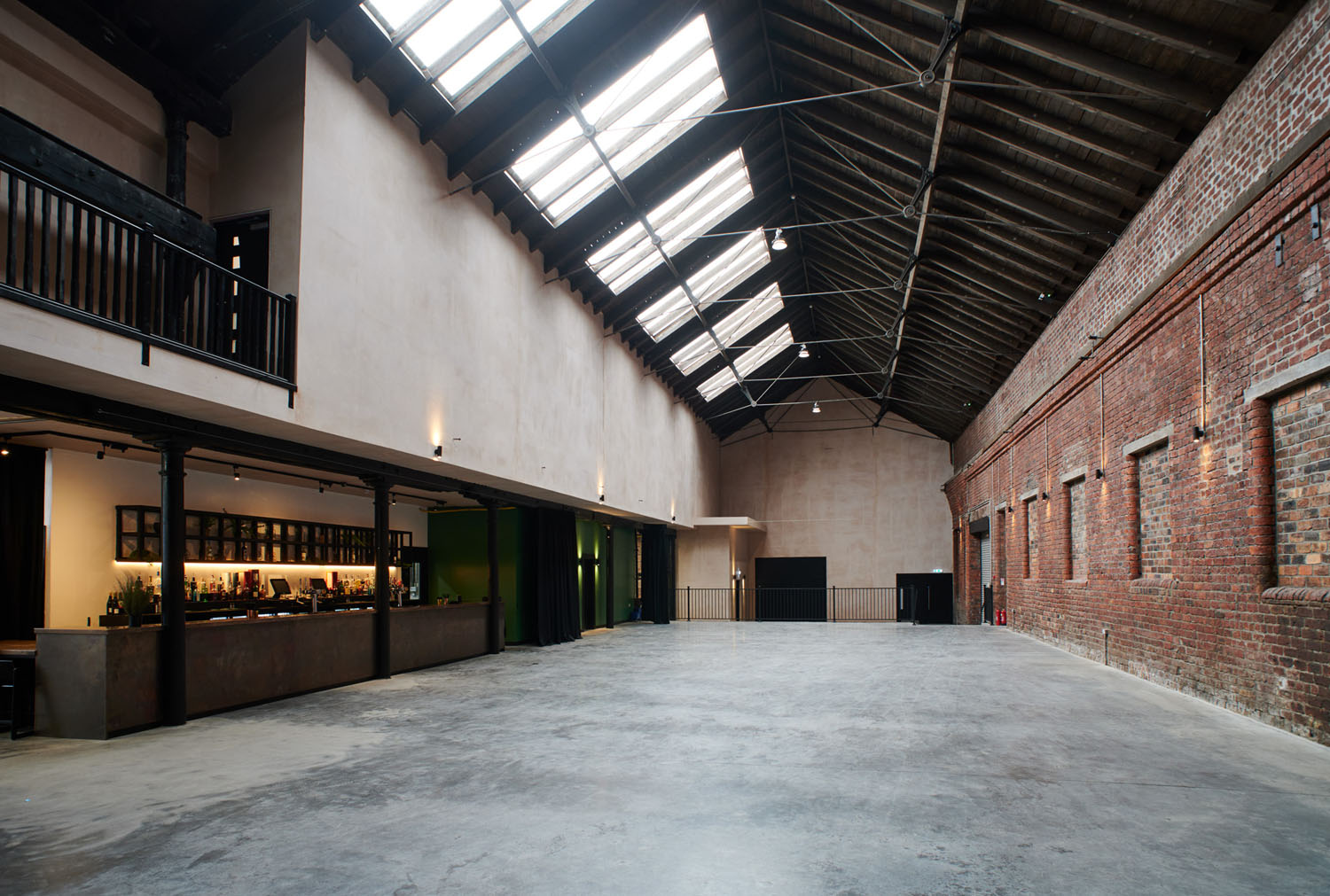 Spacious industrial event venue with high ceilings for corporate meetings and social gatherings.