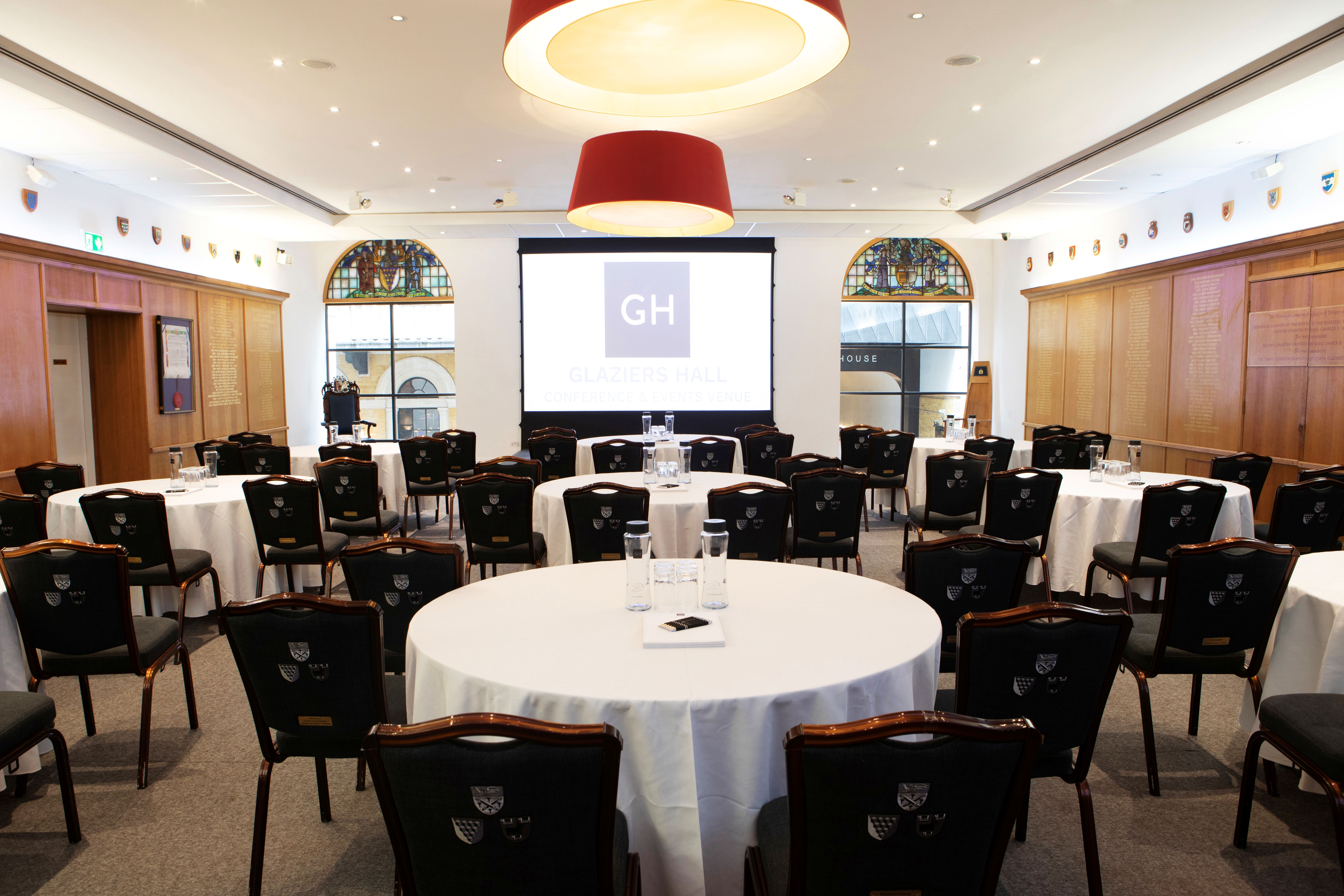Court Room and Library at Glaziers Hall, set for a conference with round tables and screen.