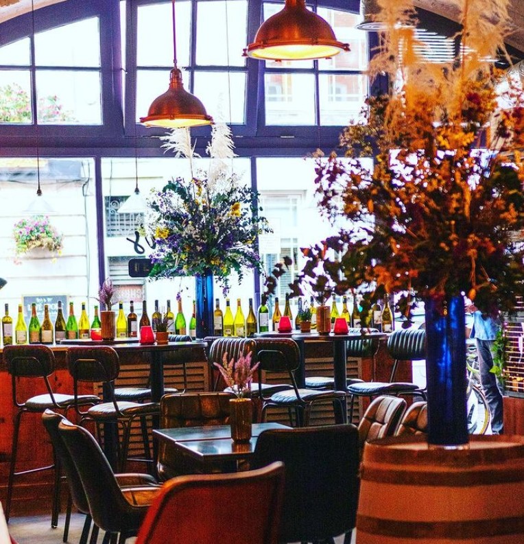 Stylish venue with vibrant bar and floral decor, perfect for social gatherings and events.