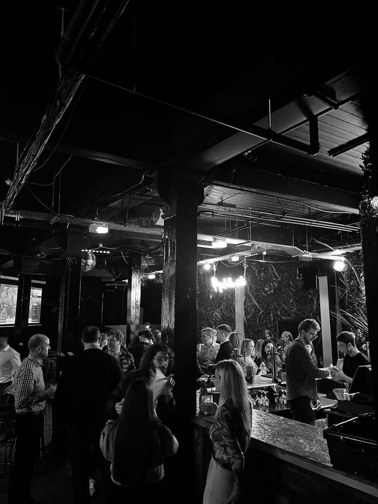 Vibrant networking event at The Lost Weekend in stylish venue with ambient lighting.