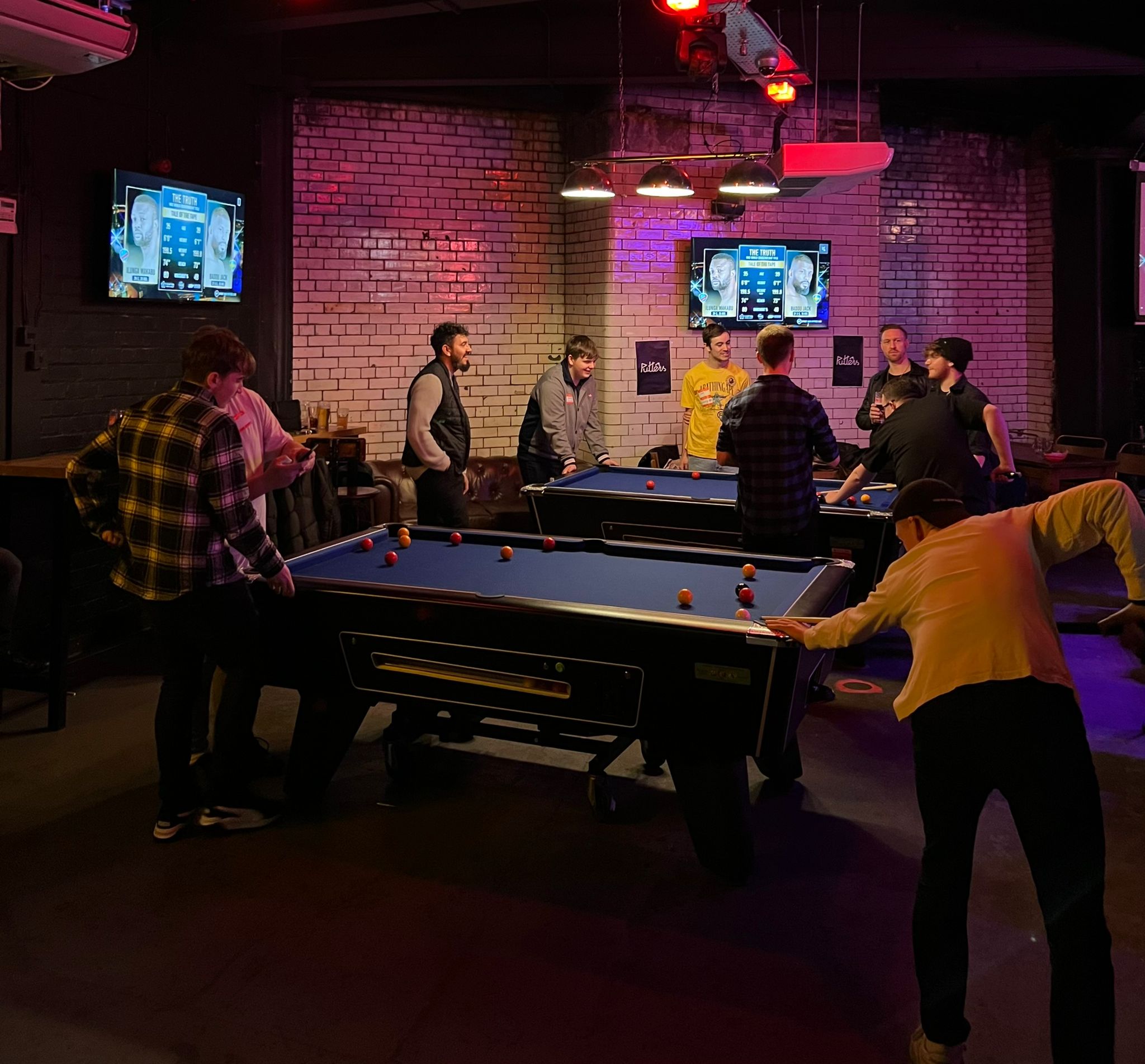 Vibrant social event space with pool tables for networking and team-building activities.
