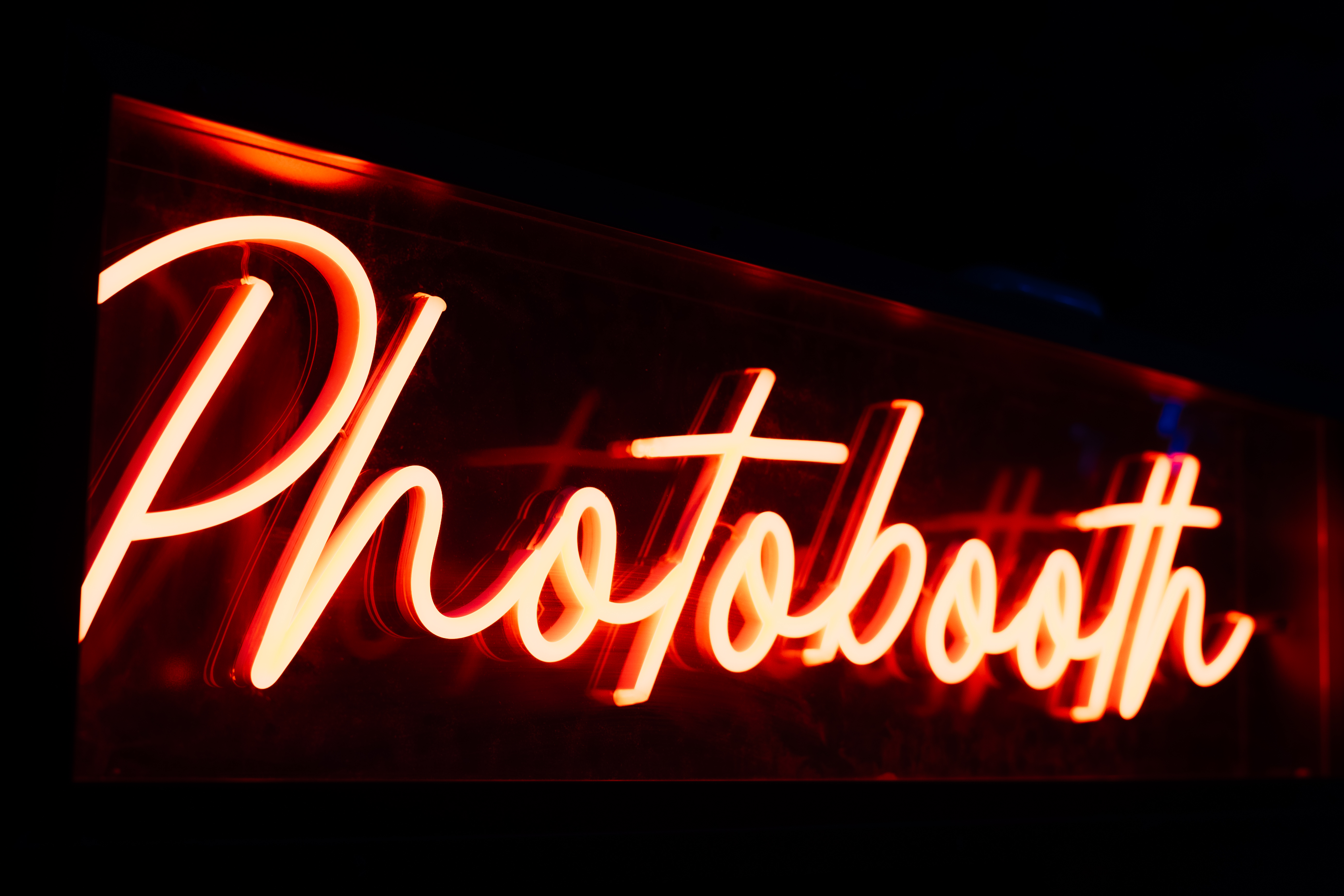 "Vibrant neon 'Photobooth' sign at The Lost Weekend, enhancing event engagement and fun."