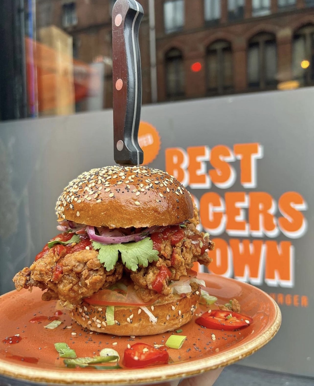 Gourmet burger with fried chicken at The Lost Weekend, perfect for events and gatherings.