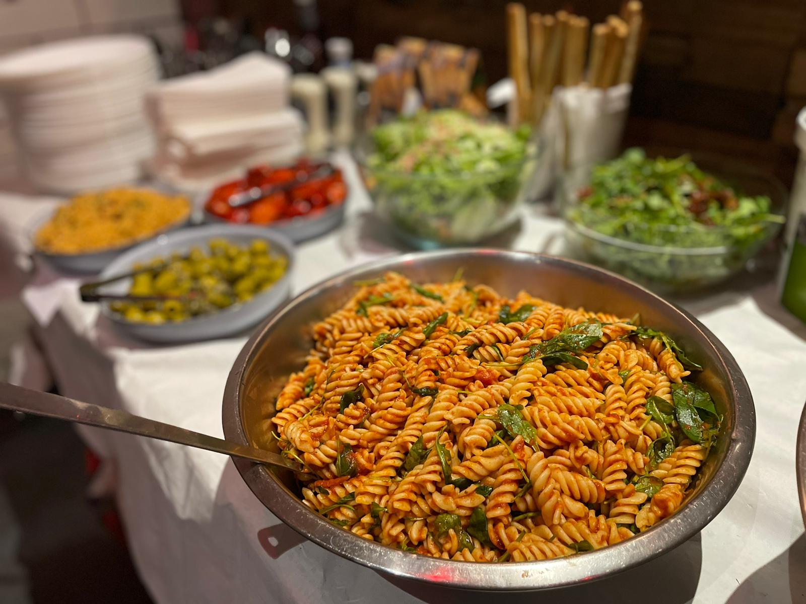 Buffet setup at The Lost Weekend with vibrant pasta dish for social gatherings.