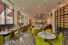 VIP area at 28-50 Oxford Circus, featuring green chairs for intimate meetings and events.