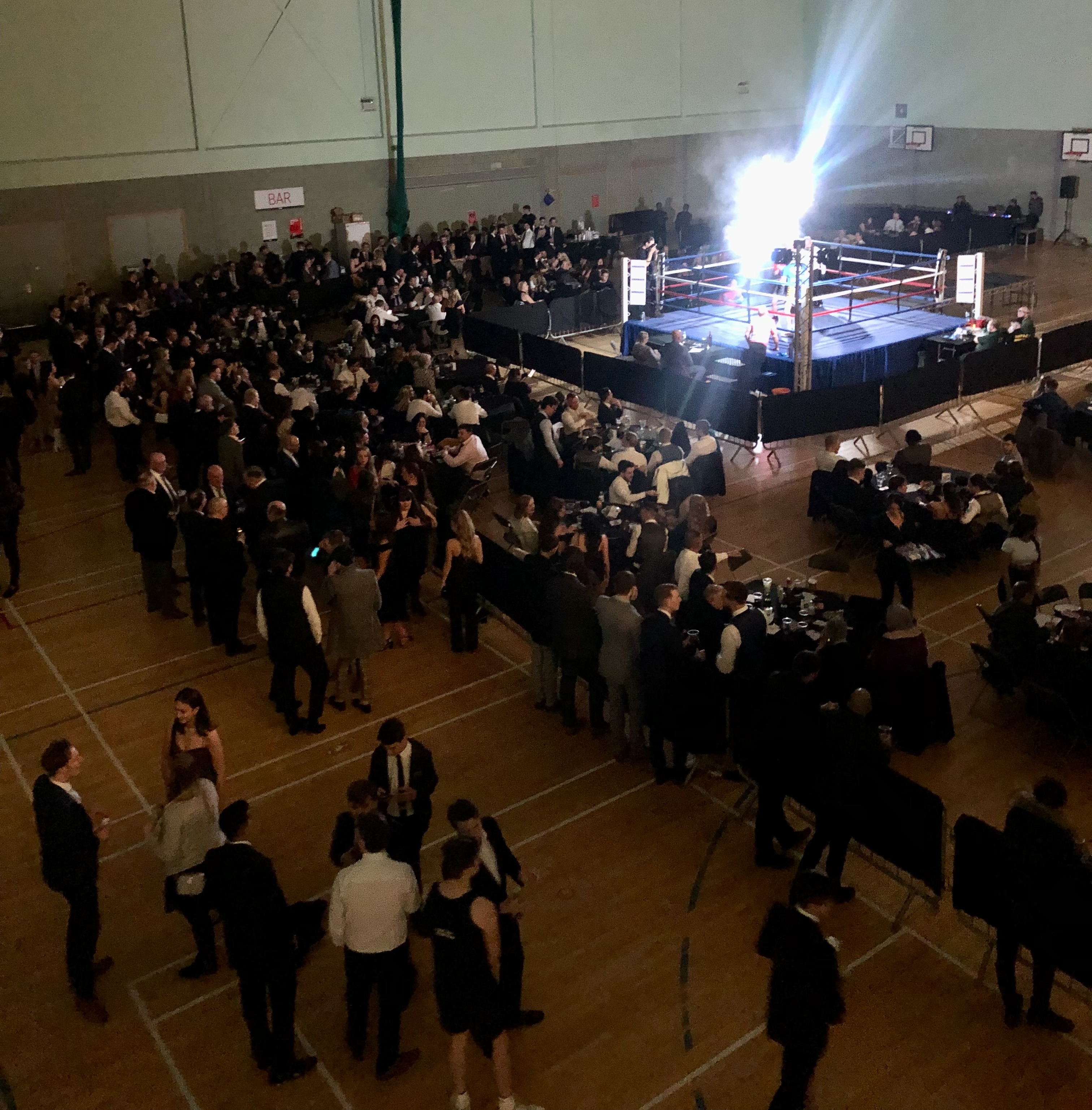Charity boxing match in Basildon Sporting Village with a vibrant crowd and illuminated ring.