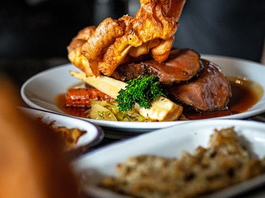 Succulent roast meat dish with vibrant vegetables at The Store Croydon event venue.