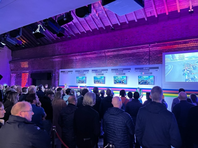 Vibrant event space at The Engine Works with engaged audience for live presentation.