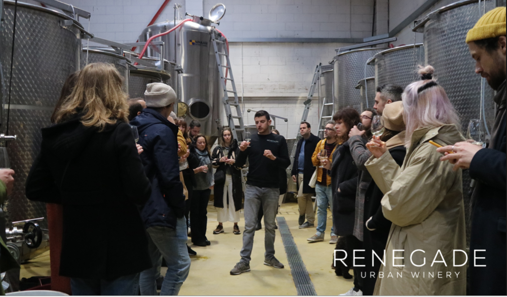 Wine tasting event at Renegade Urban Winery with fermentation tanks, ideal for corporate gatherings.