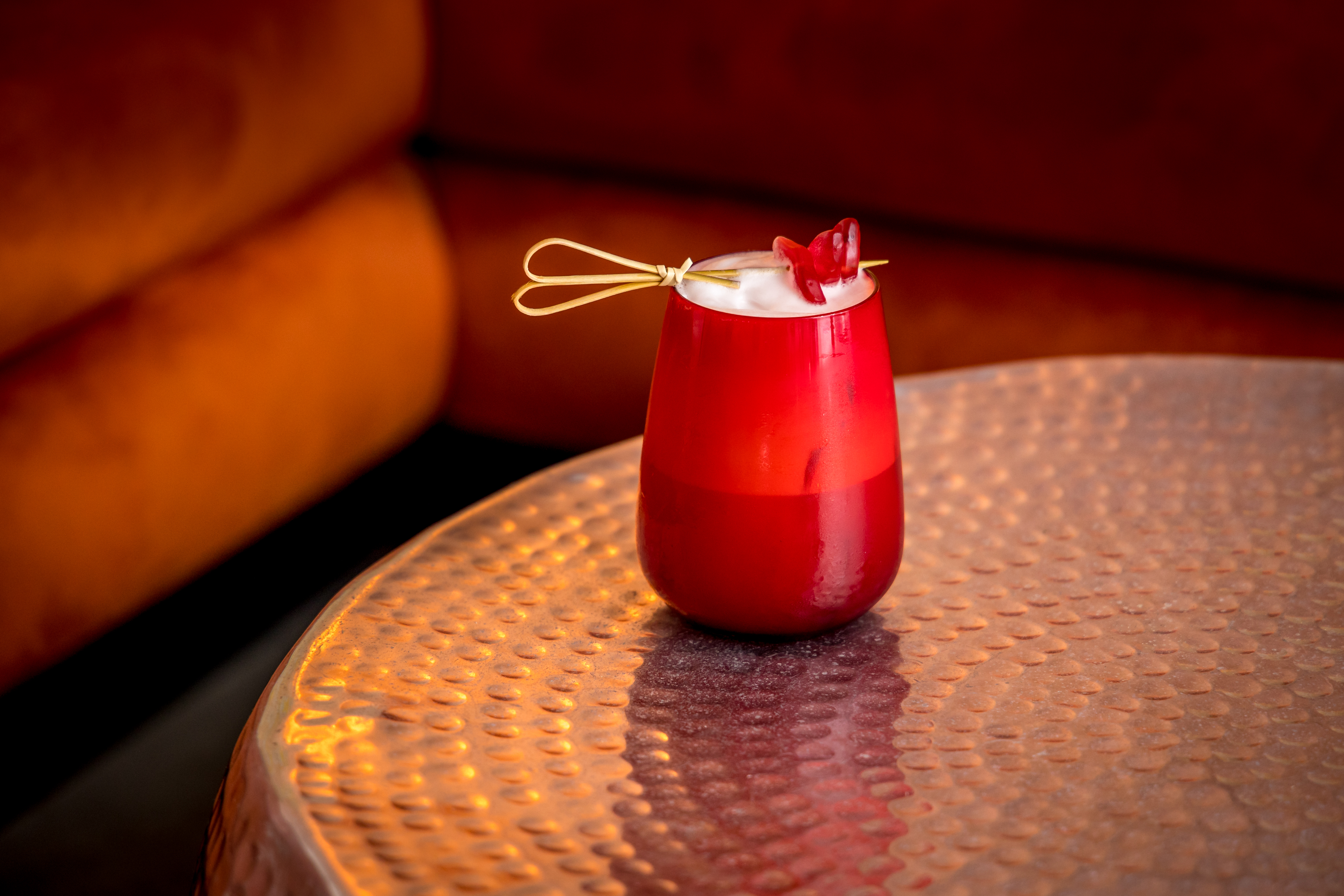 Vibrant cocktail on copper table at The Vault, ideal for networking events and celebrations.